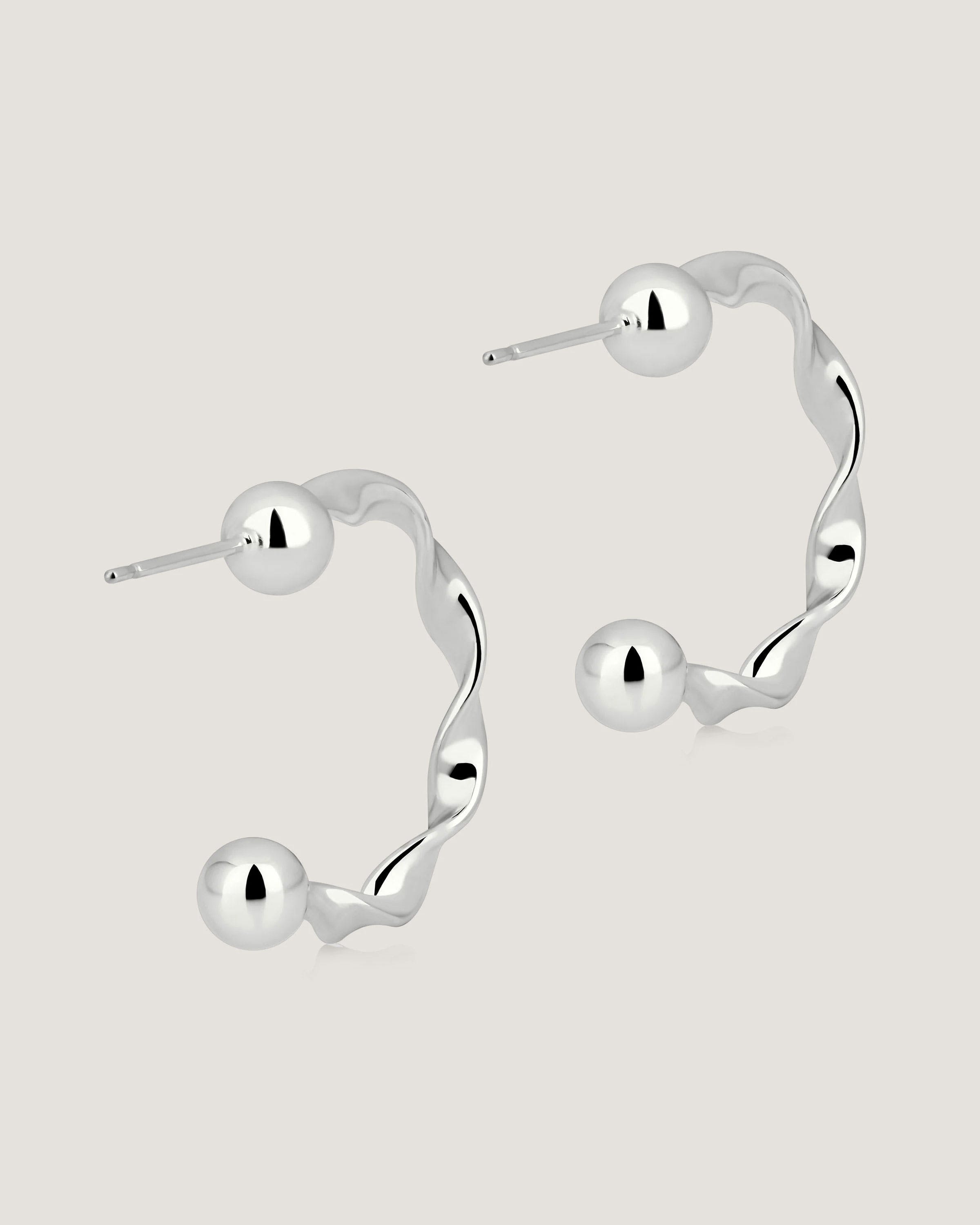 A pair of silver hoop earrings on a white background