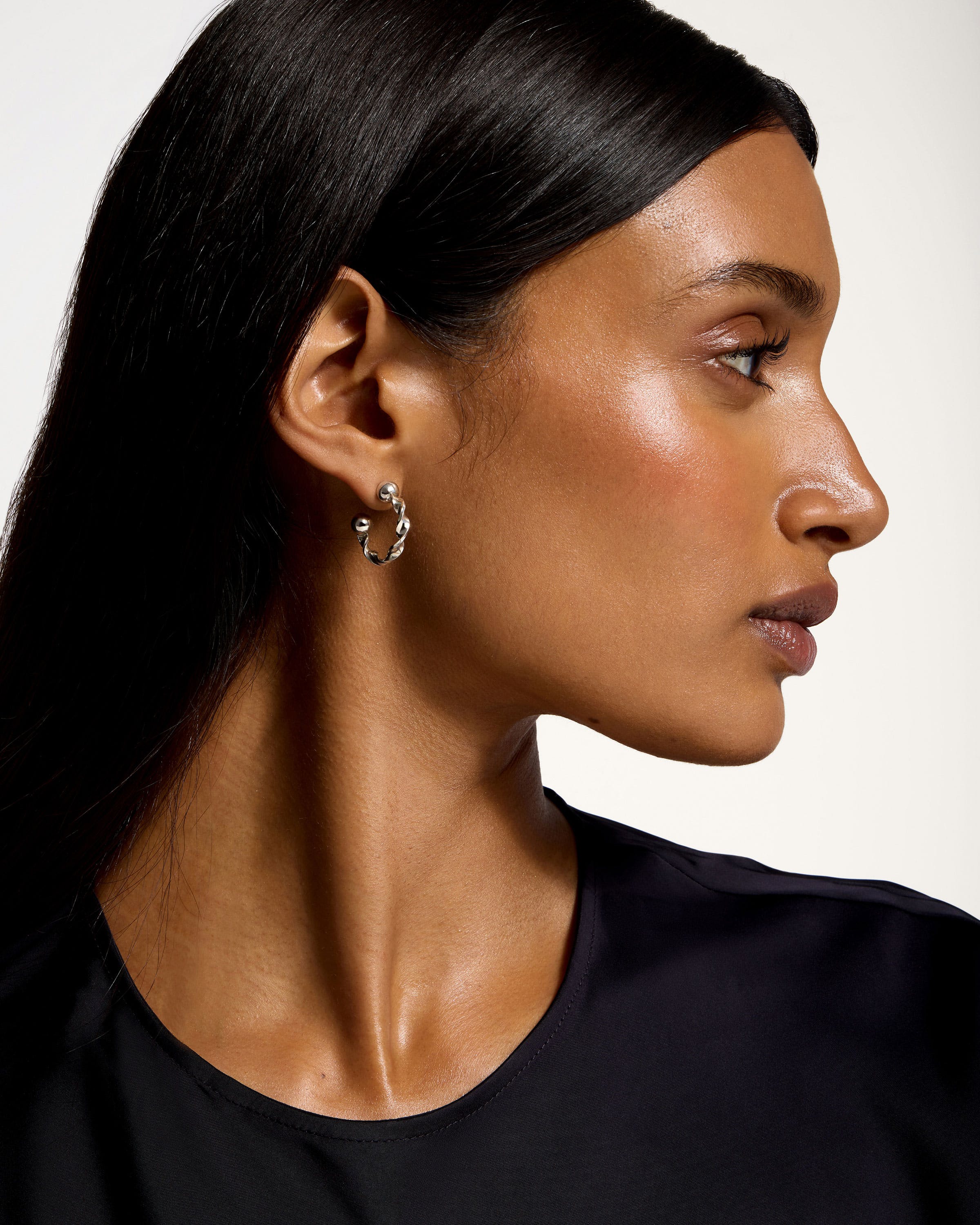 A woman wearing a black shirt and a pair of earrings