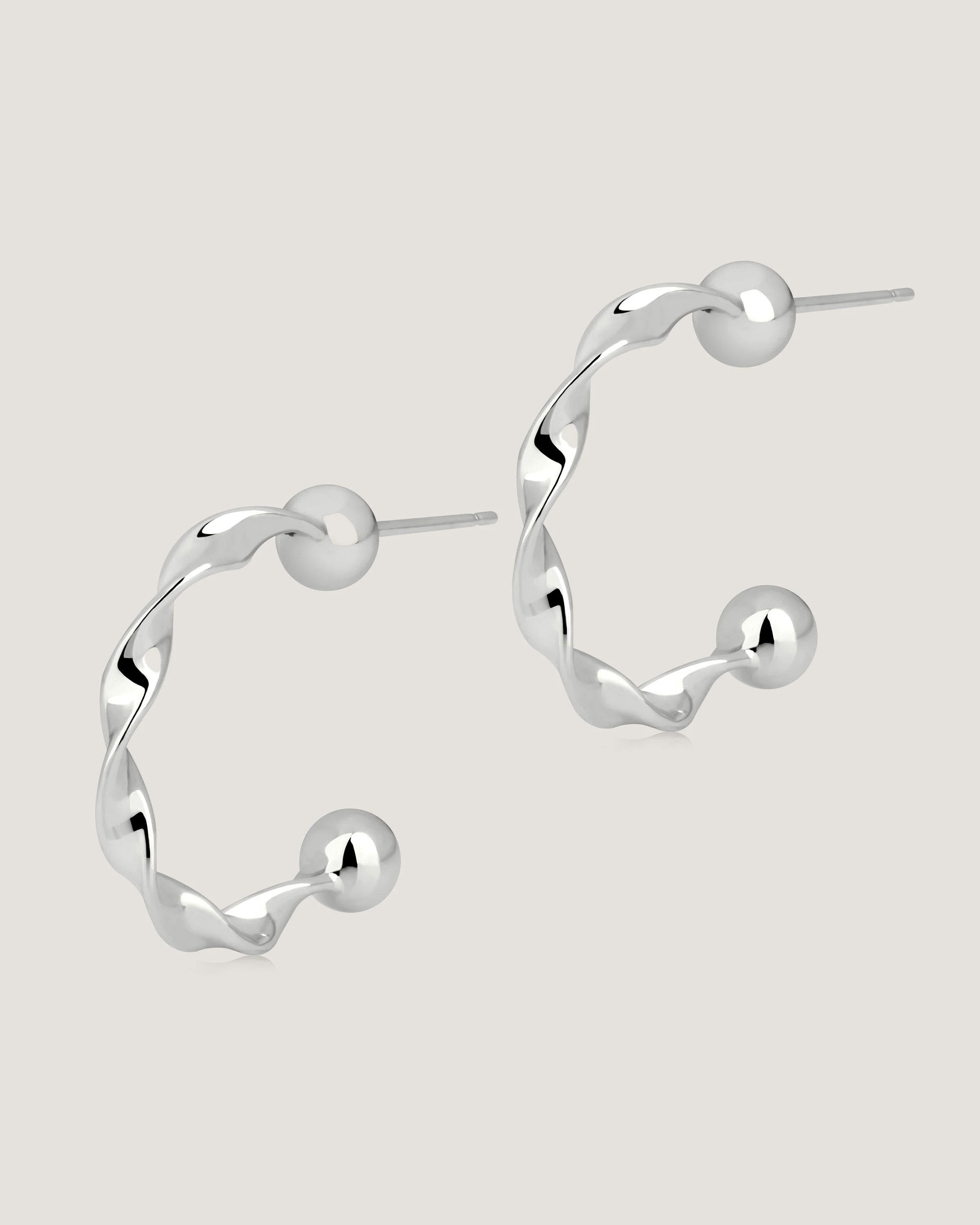 A pair of silver hoop earrings on a white background