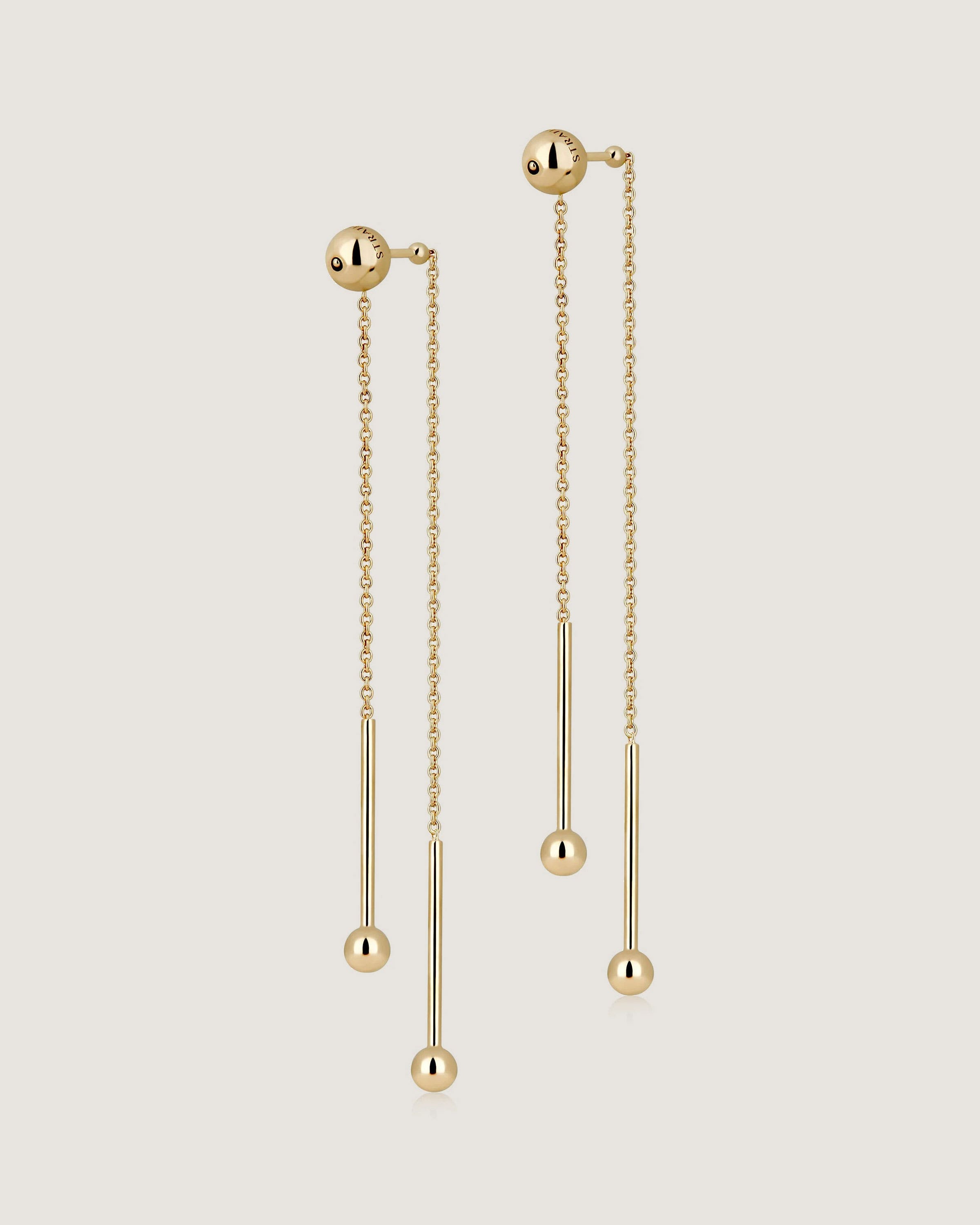 A pair of gold earrings with chains hanging from them