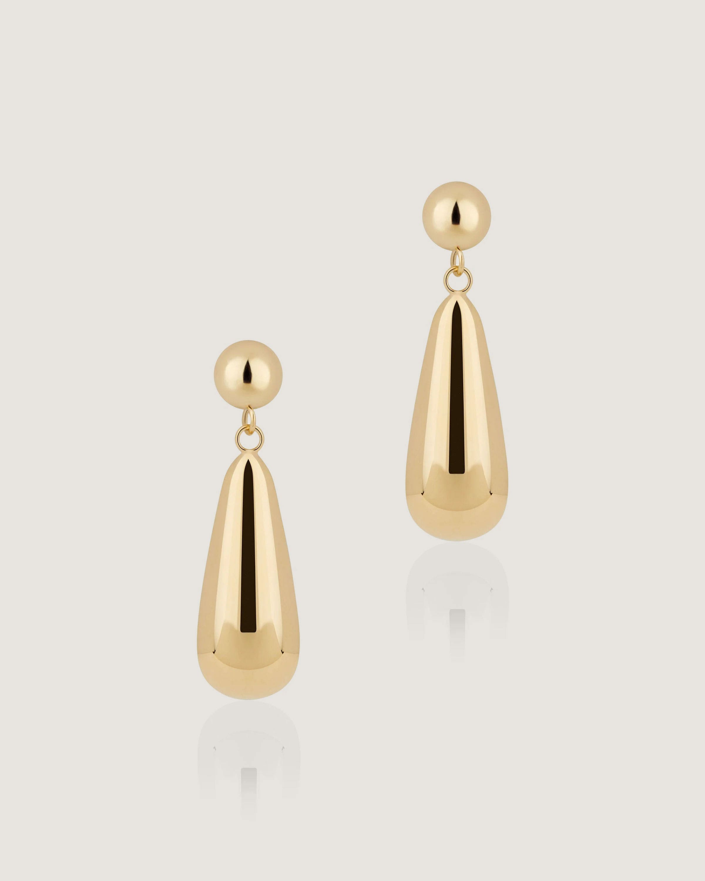 A pair of gold earrings on a white background