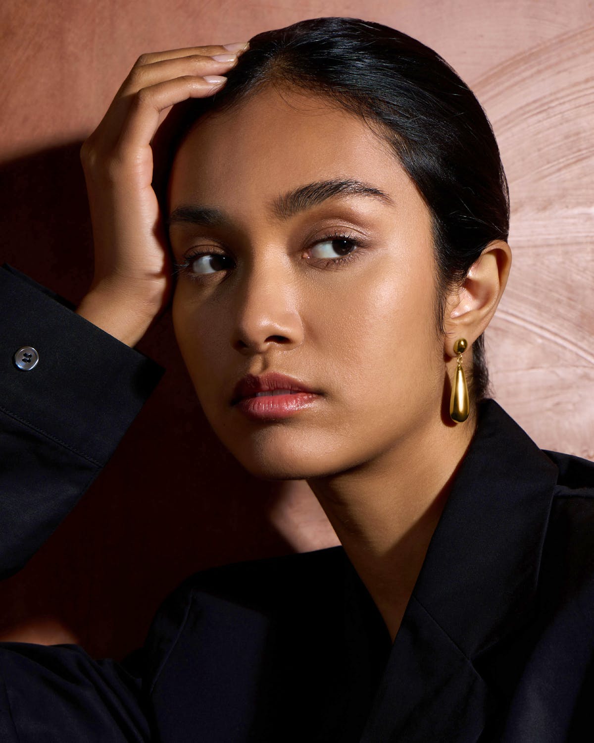 A woman in a black shirt and gold earrings