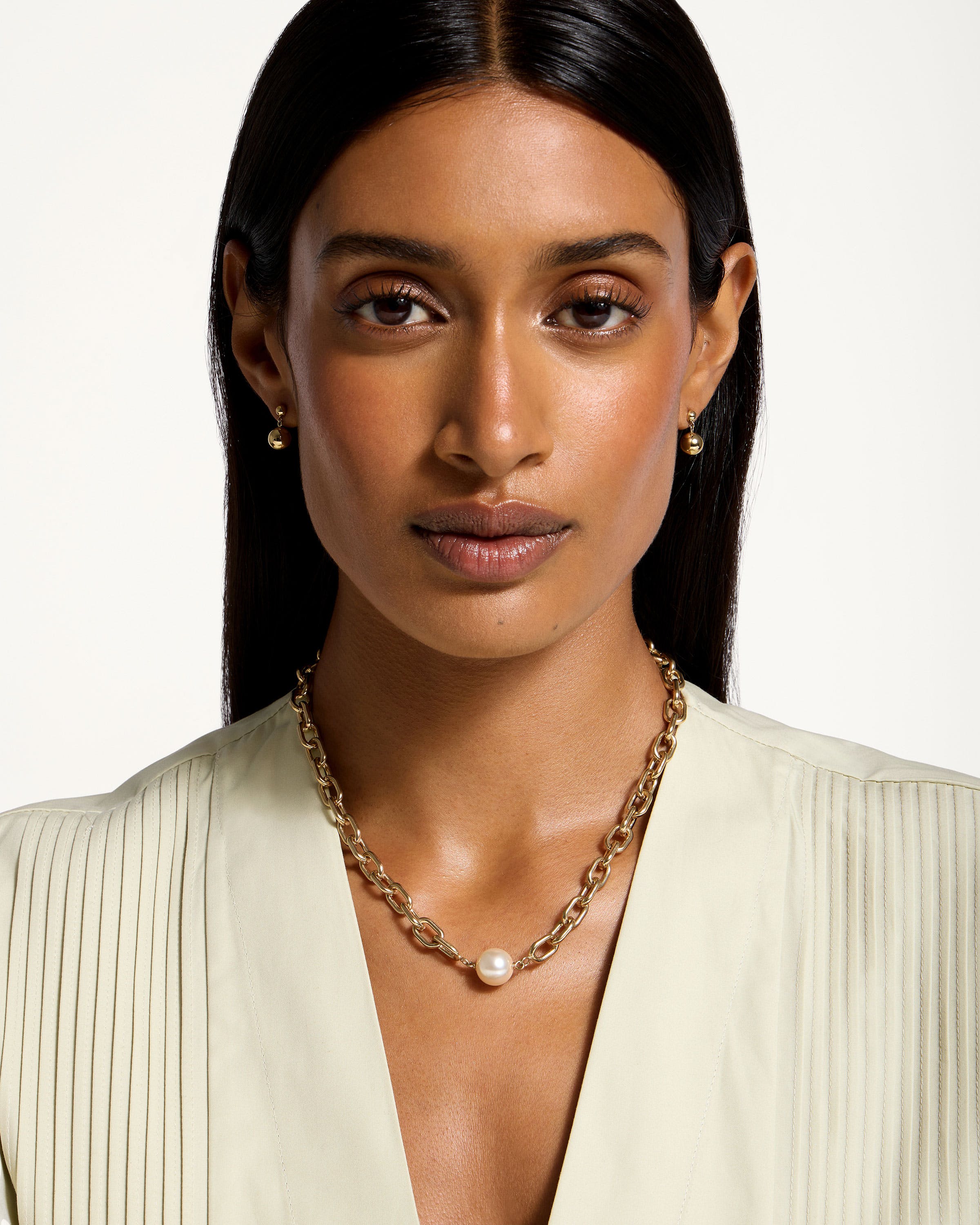 A woman wearing a necklace and a white shirt