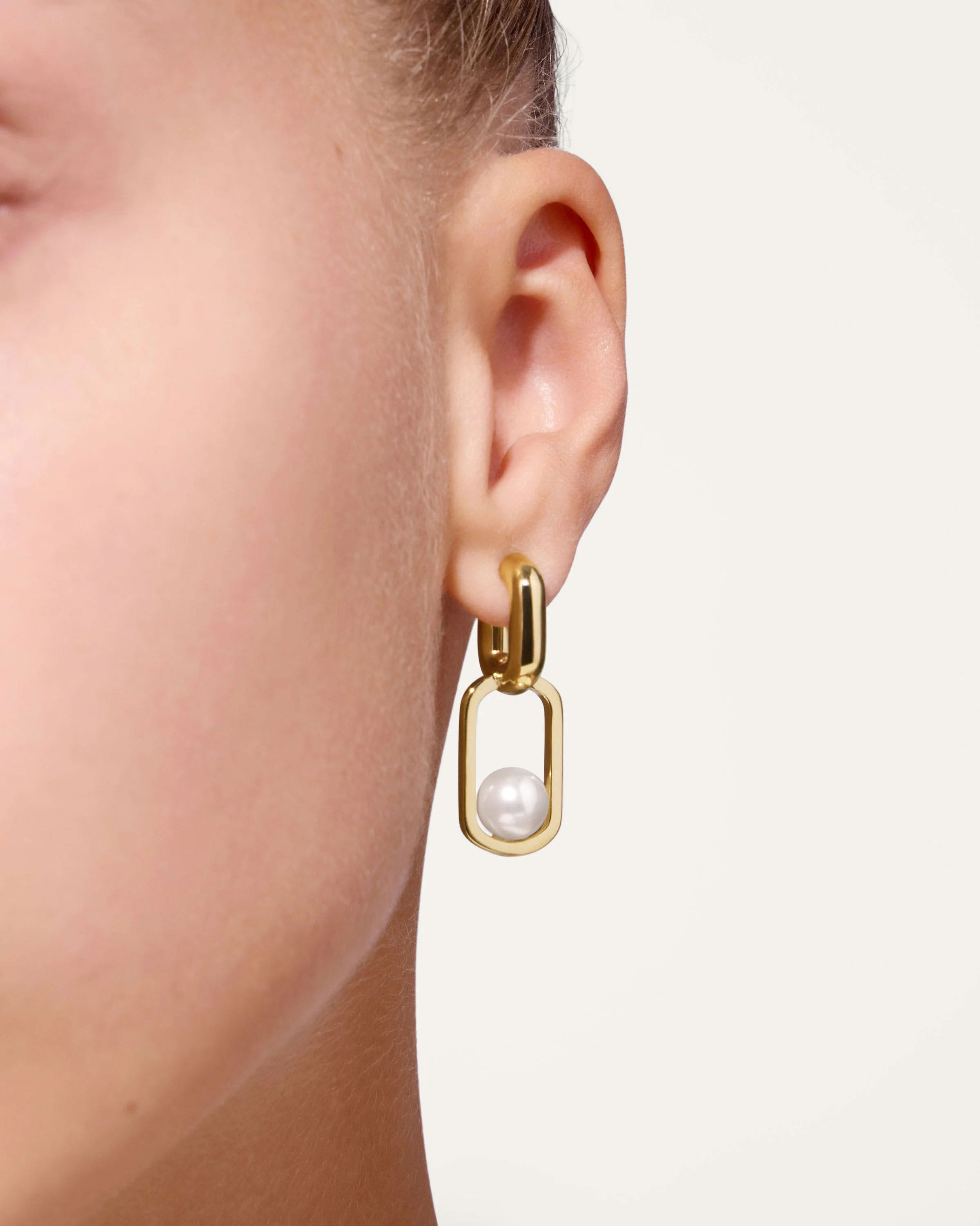 A close up of a person wearing a pair of earrings