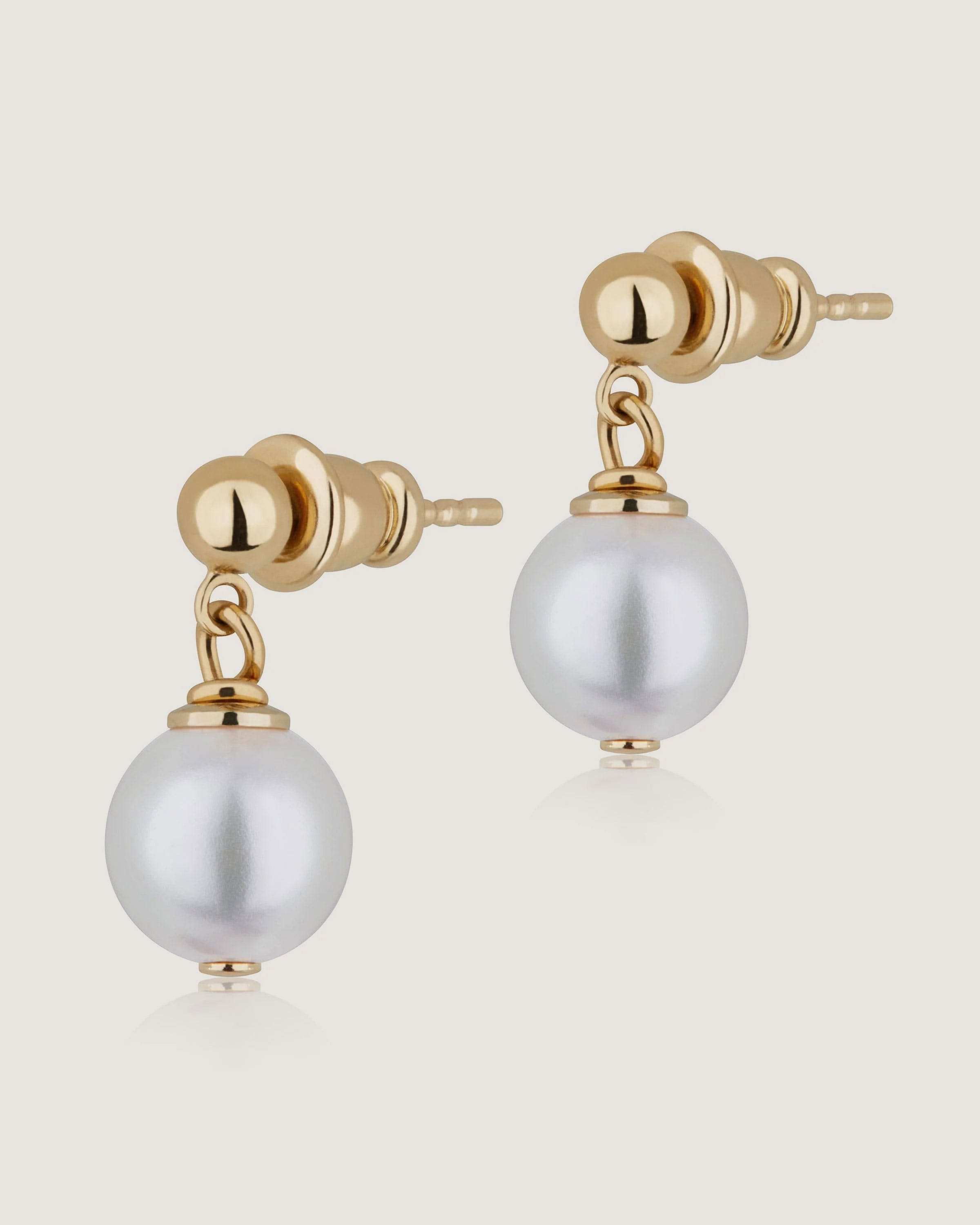 A pair of earrings with pearls on a white background