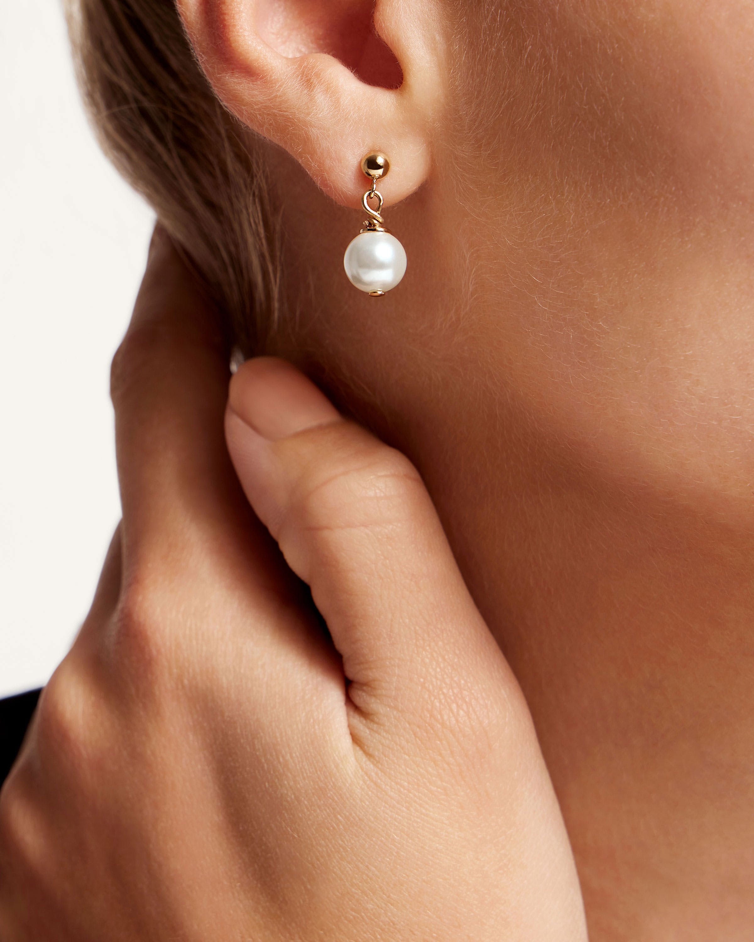 A close up of a person wearing a pair of earrings