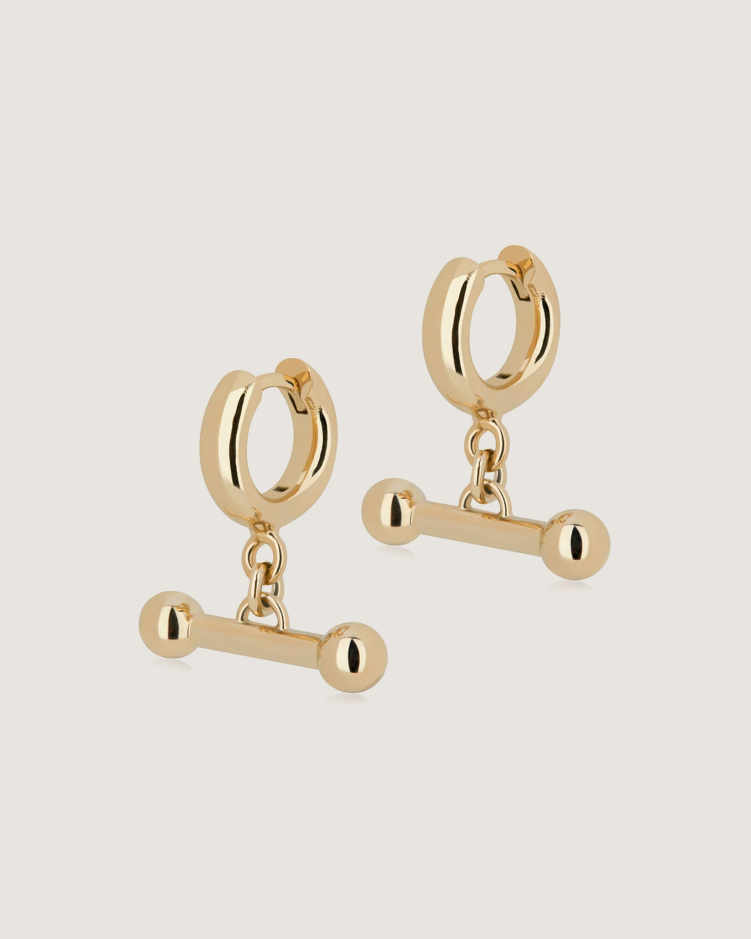 A pair of gold earrings with a chain