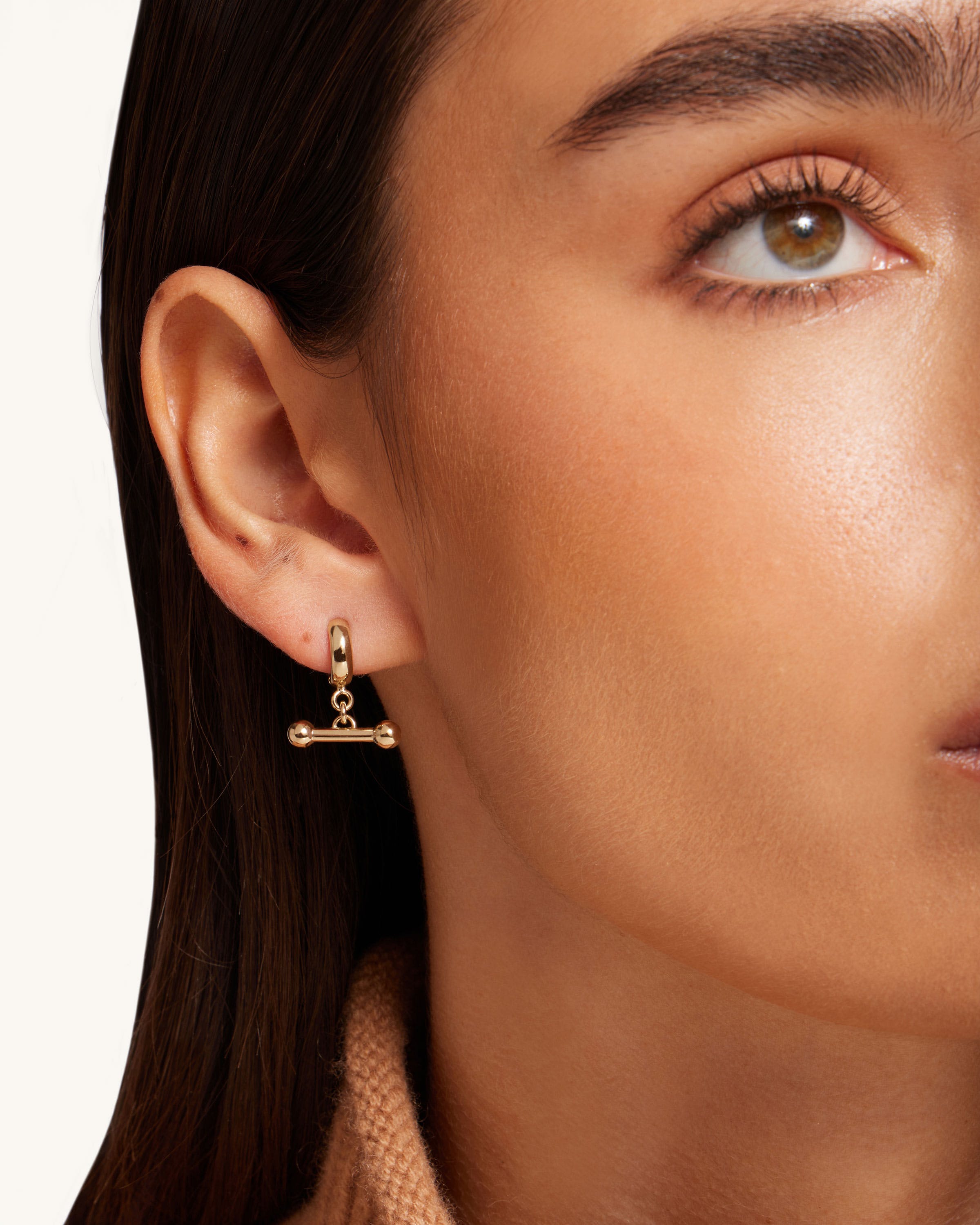 A close up of a person wearing a pair of earrings