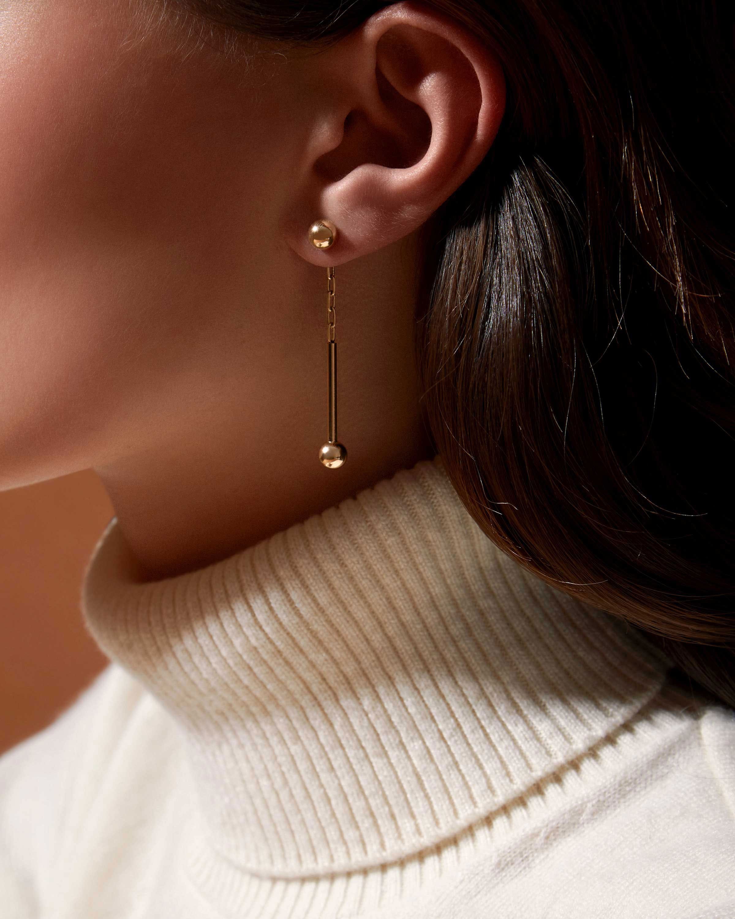 A close up of a person wearing a pair of earrings