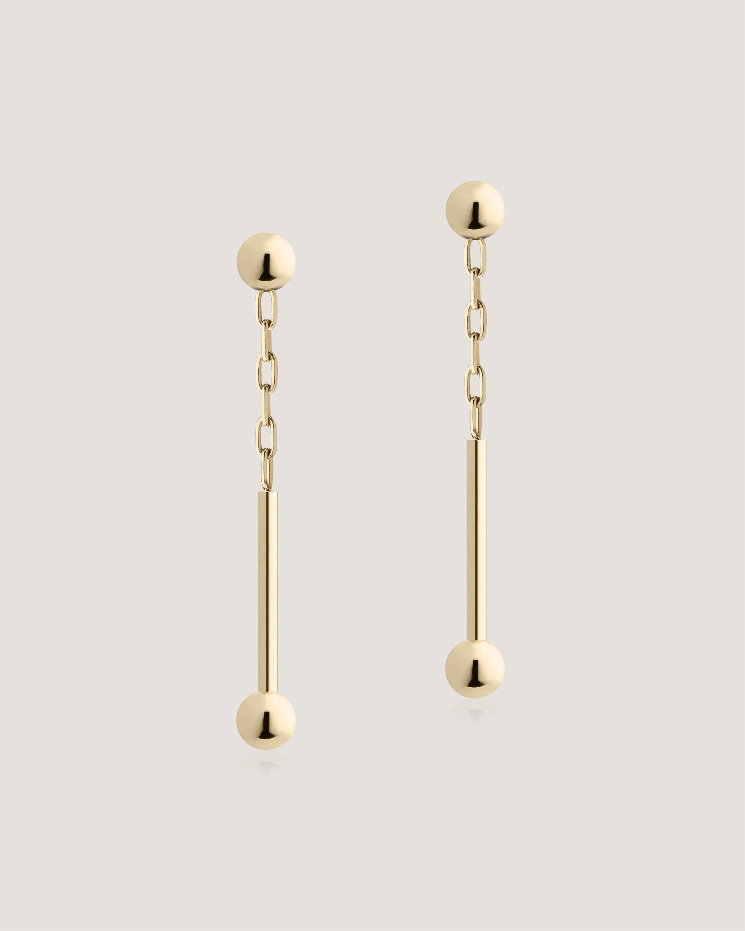 A pair of gold earrings with a long chain