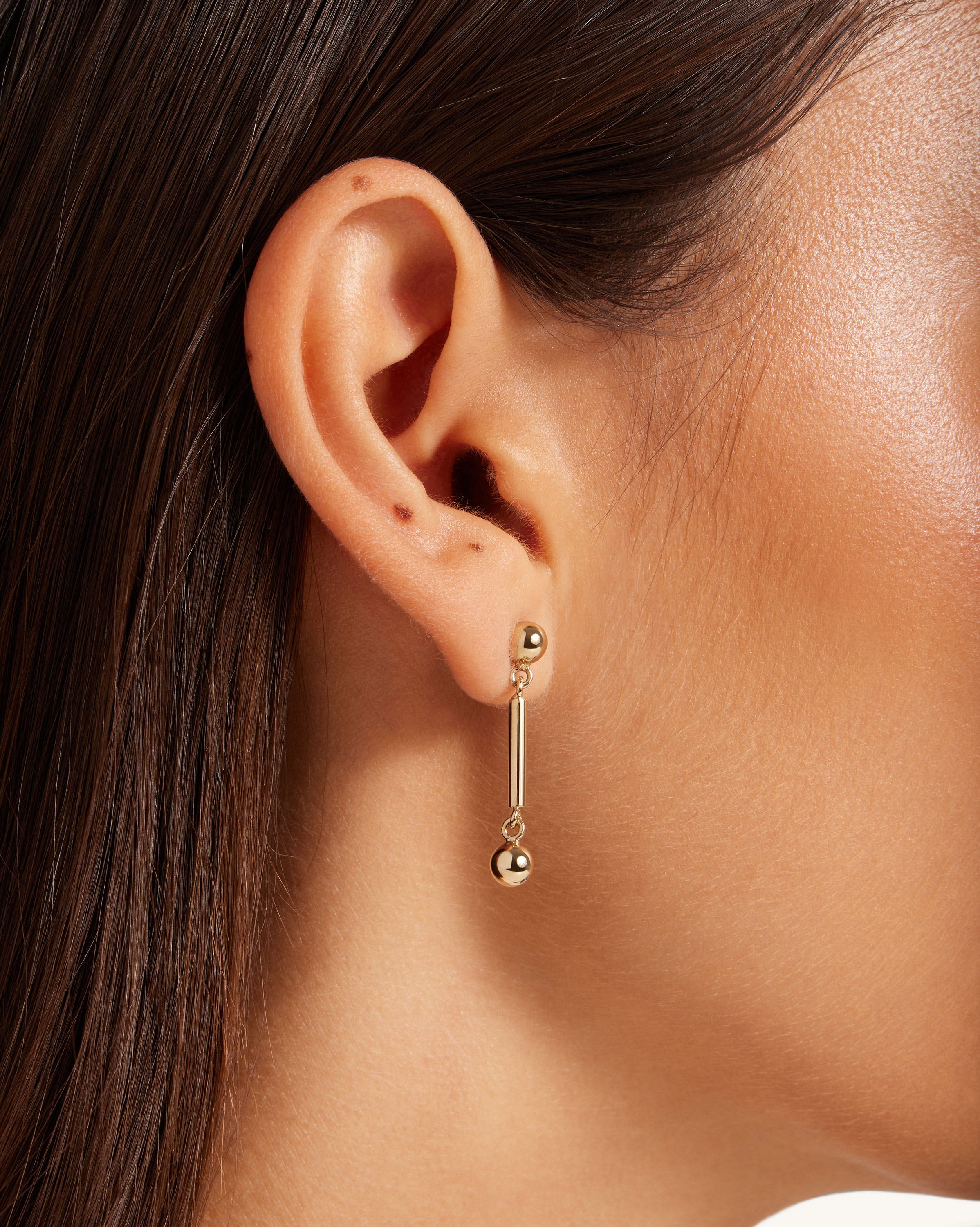 A close up of a person wearing a pair of earrings