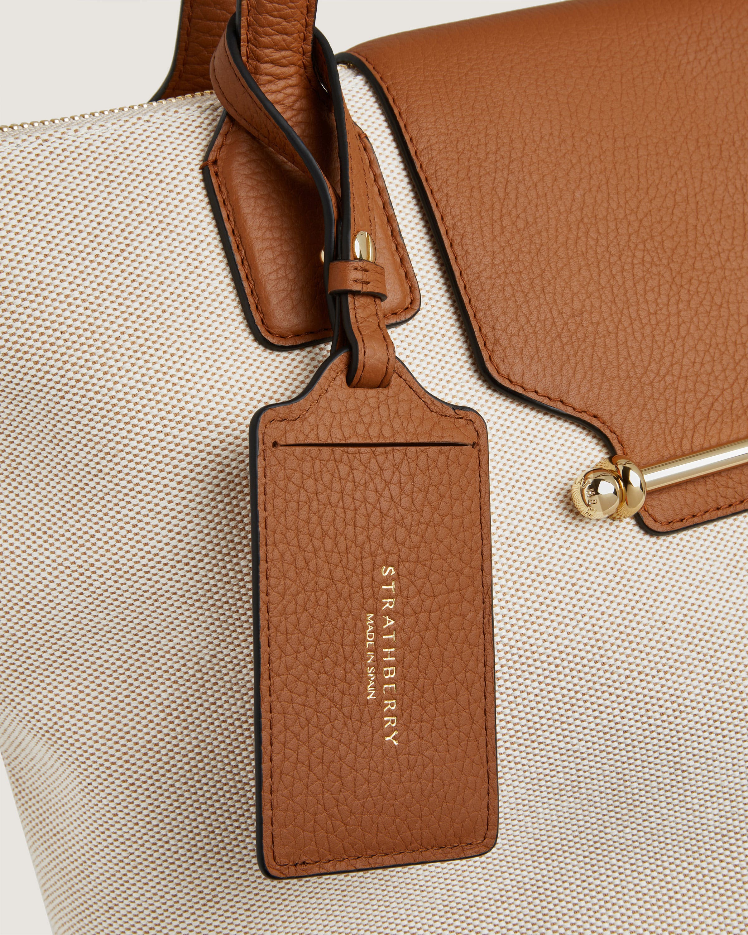 A brown and white bag with a tag on it