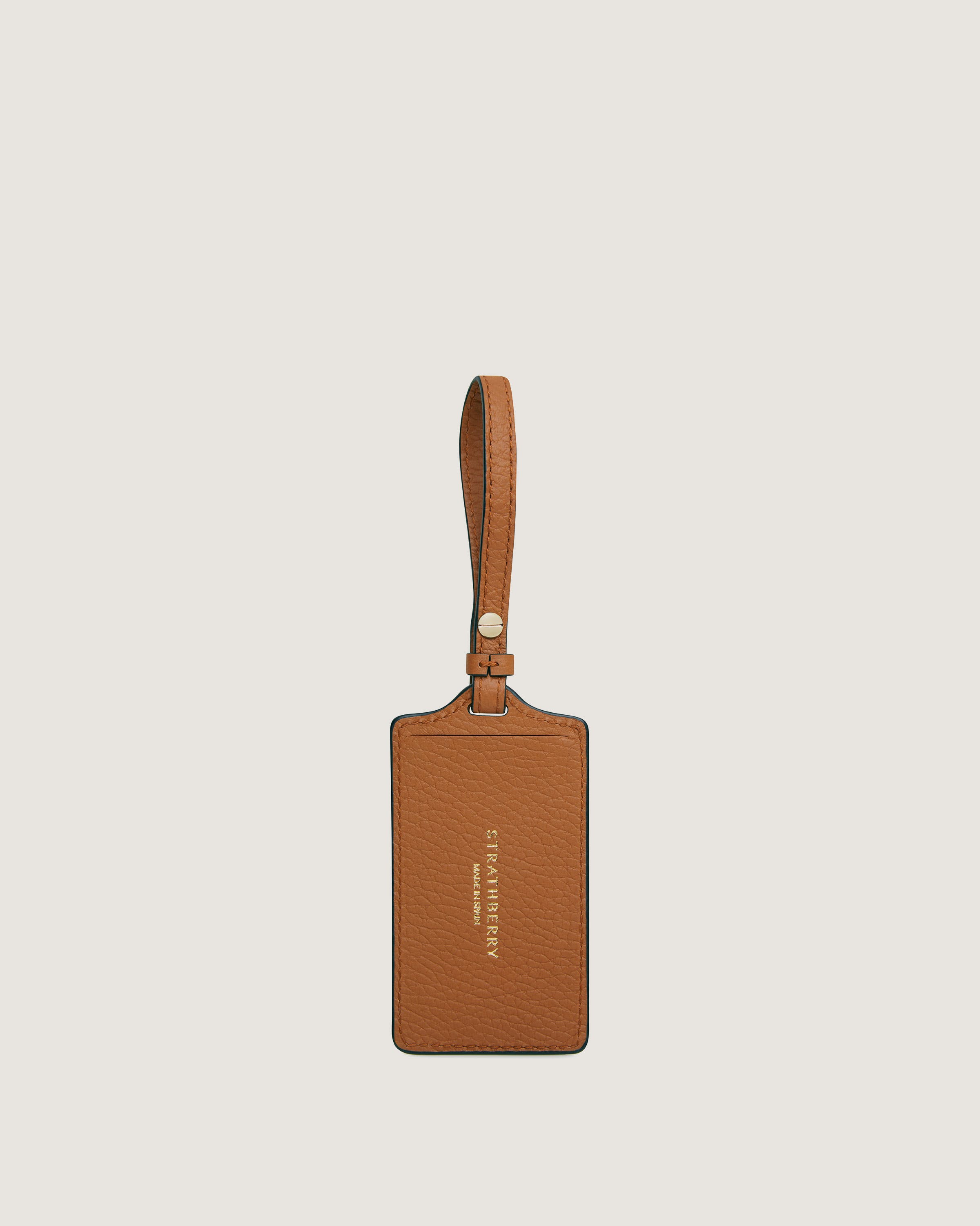 A tan leather luggage tag hanging from a string