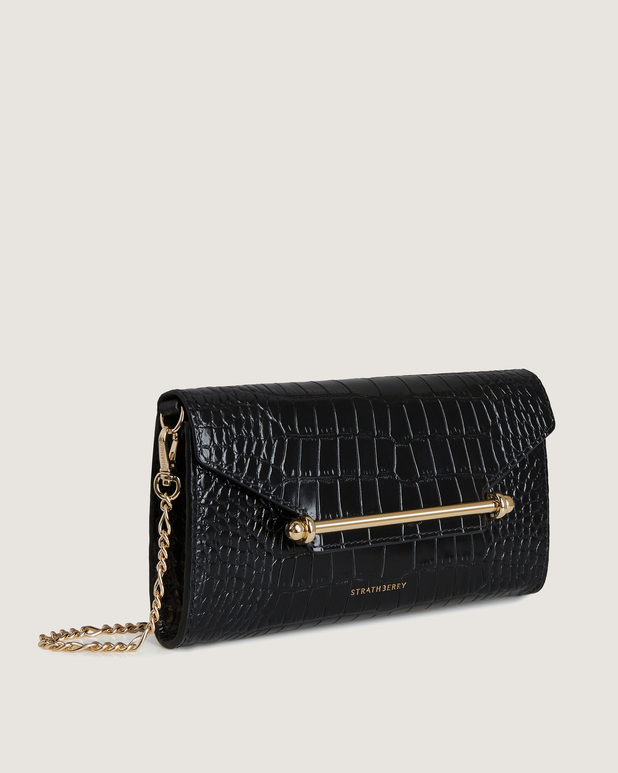 A black purse with a gold chain hanging from it