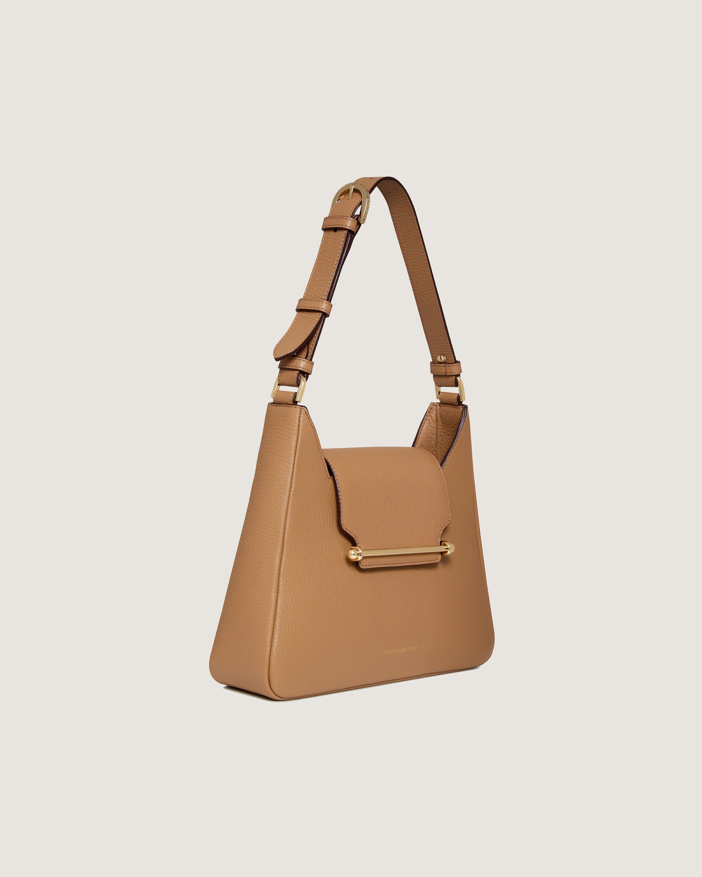 A tan handbag with a gold handle