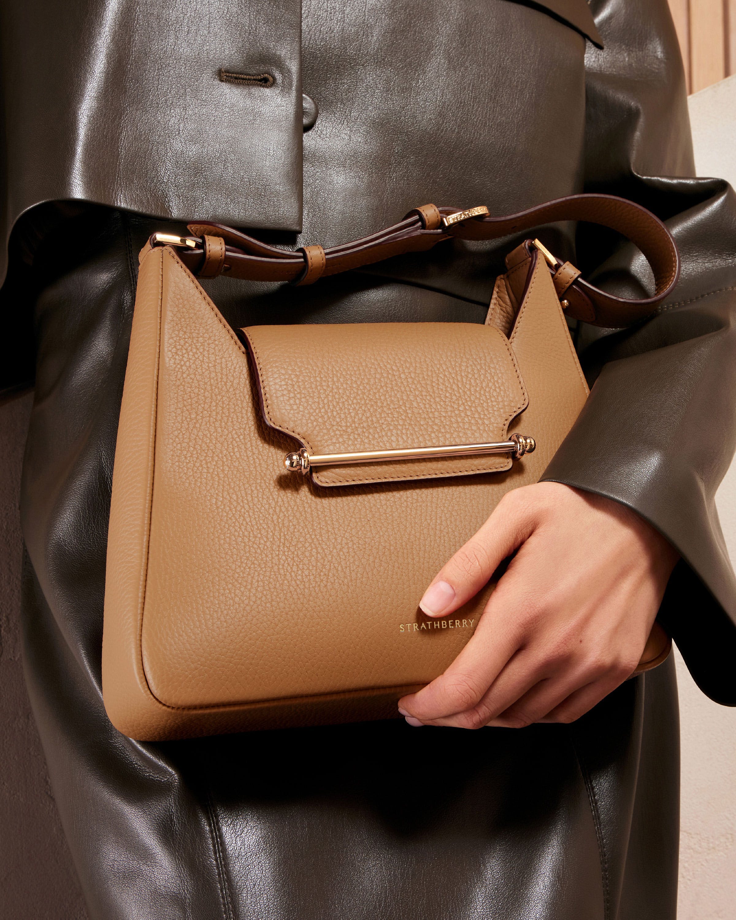 A woman holding a brown purse in her hand