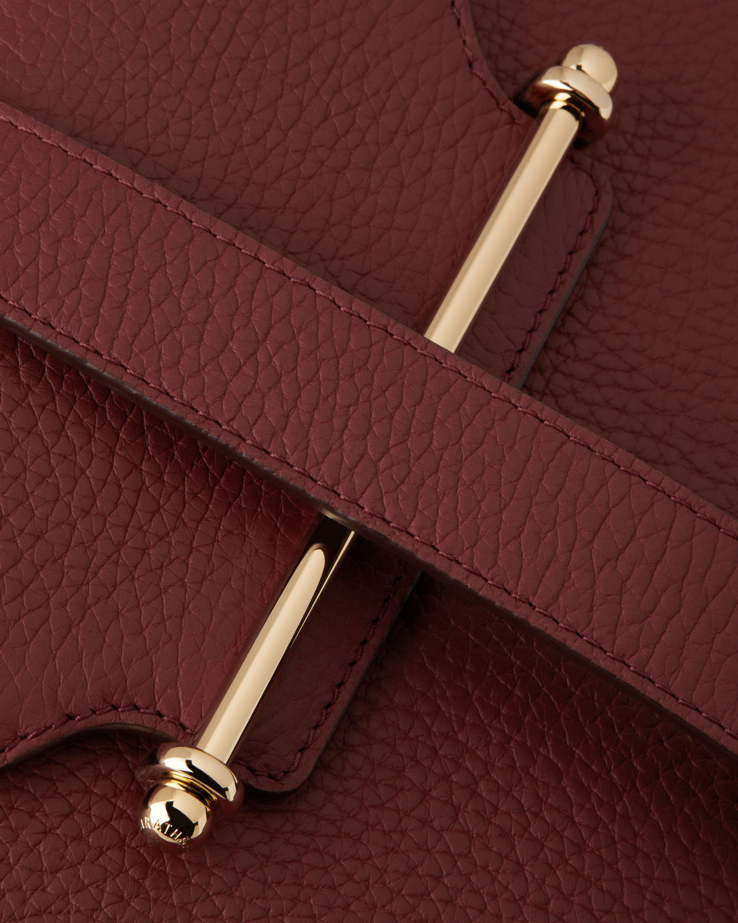 A close up of a red purse with a gold handle