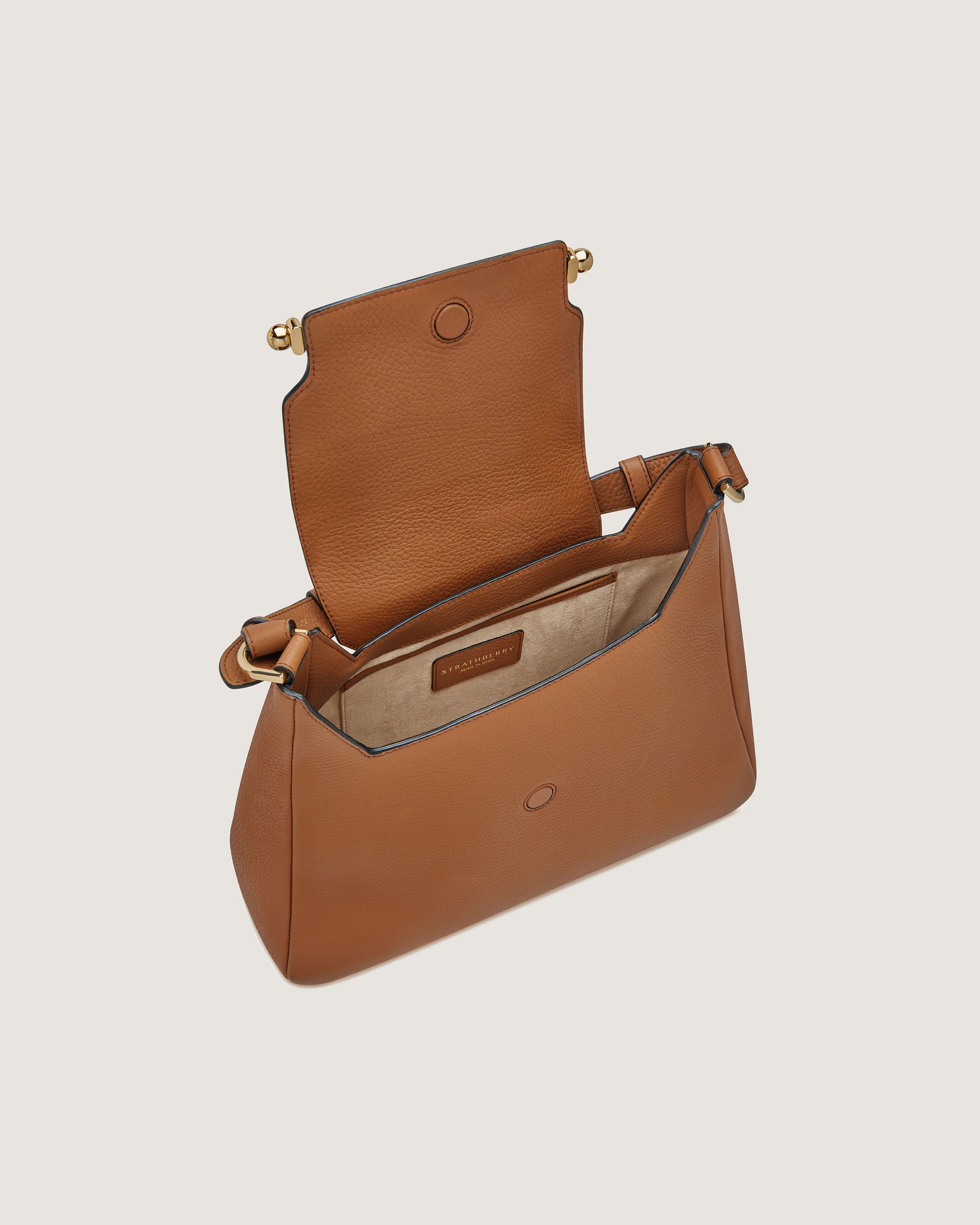 A brown leather purse with a strap