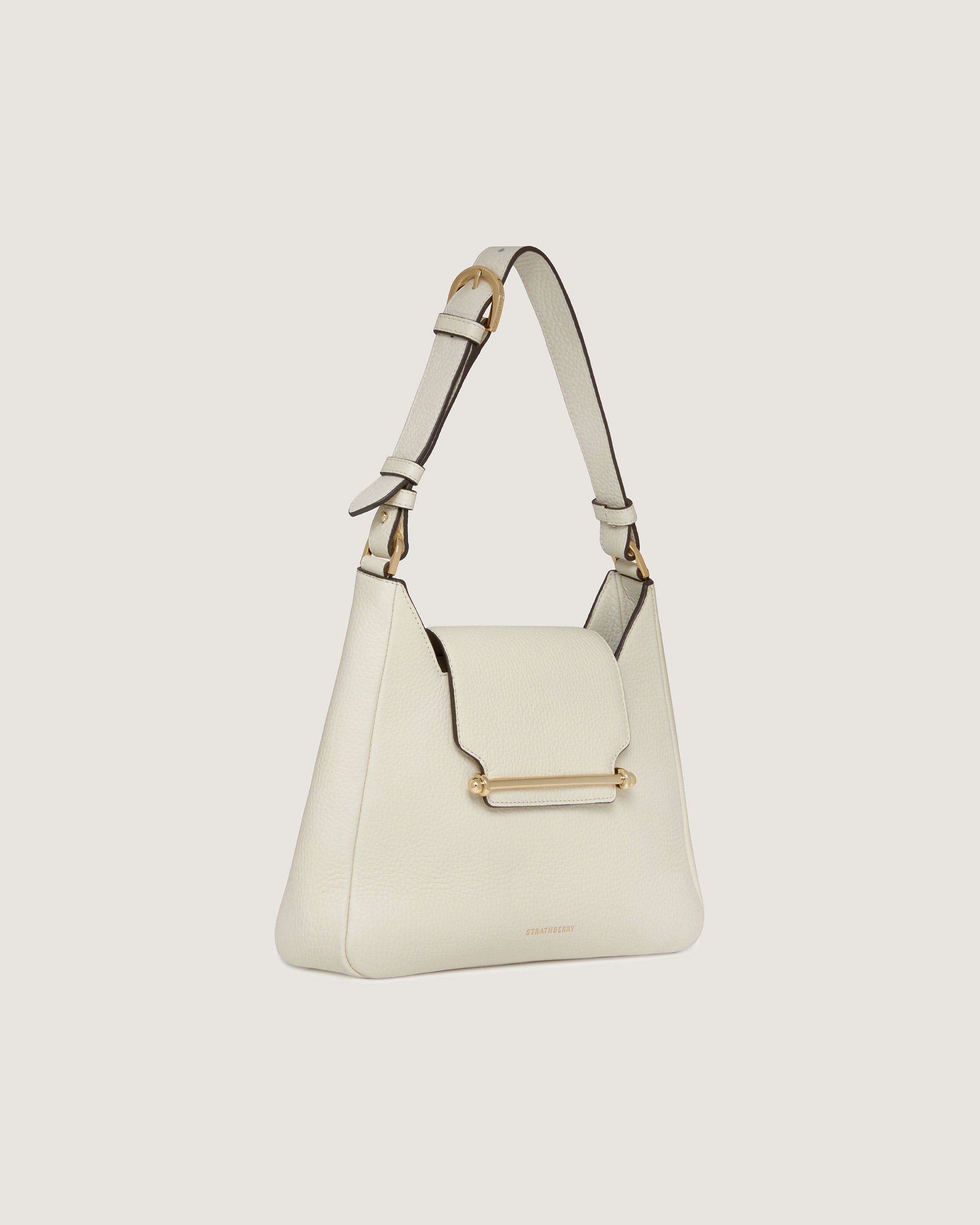 A white handbag with a gold handle