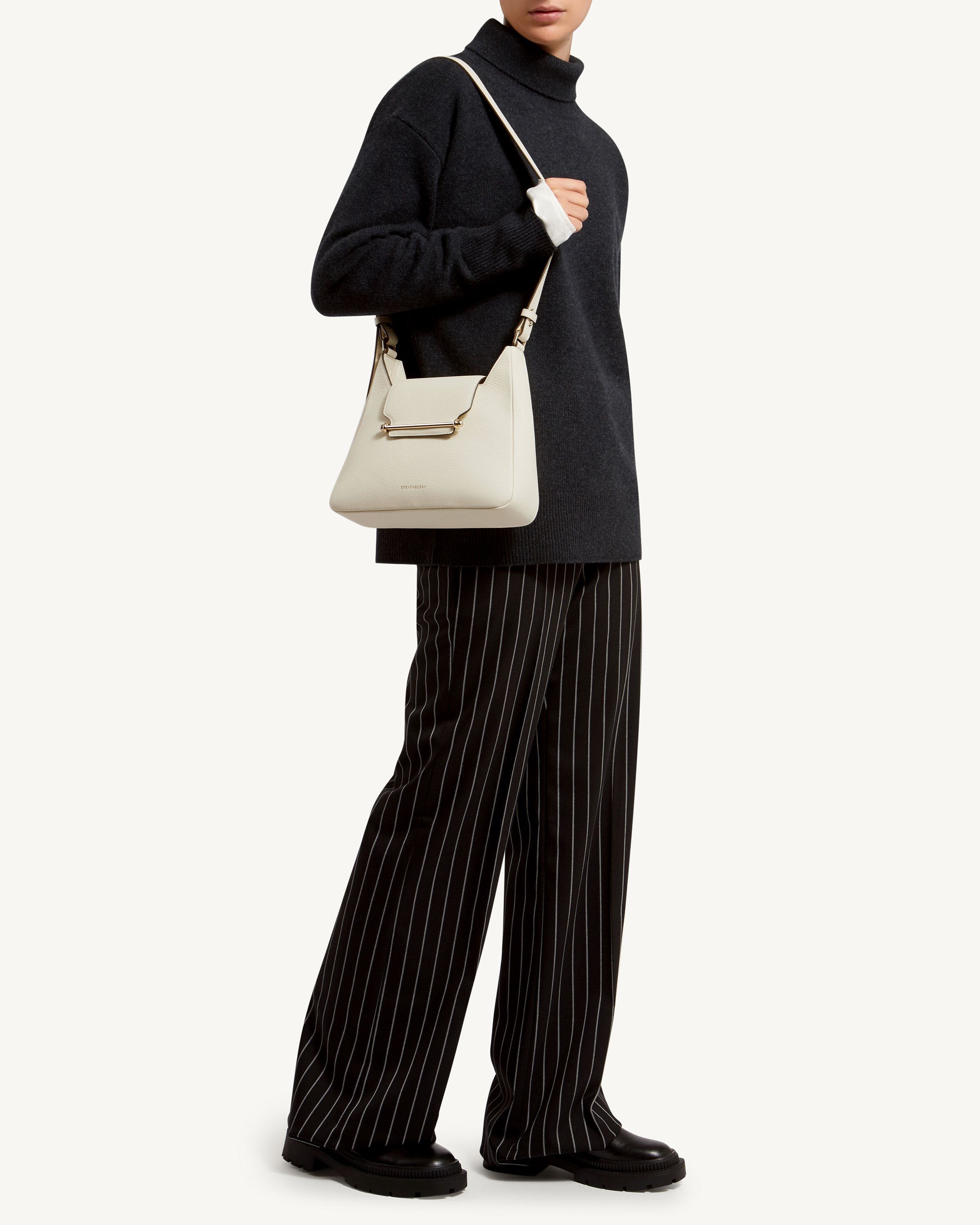 A woman is holding a white handbag