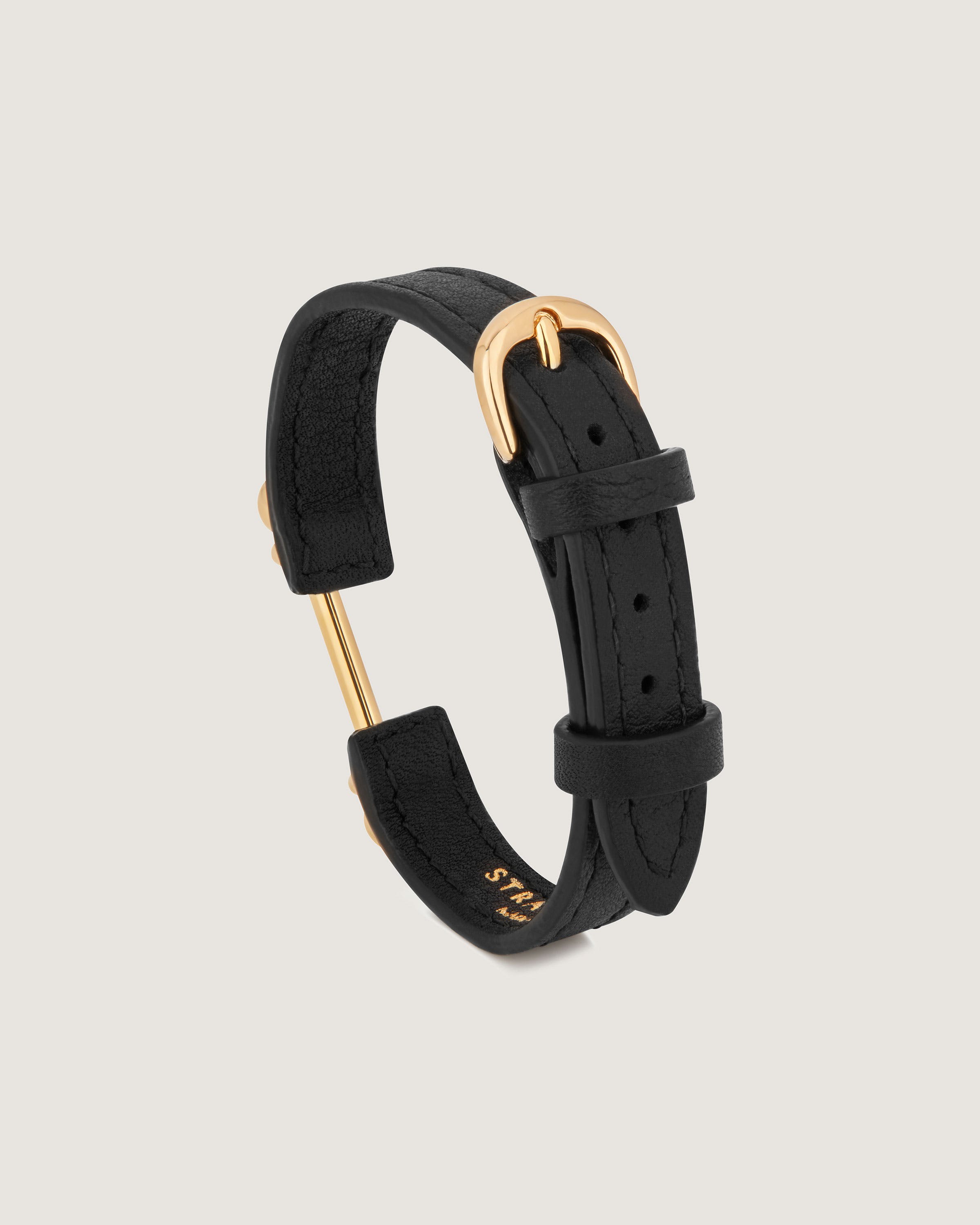 A black leather bracelet with a gold clasp