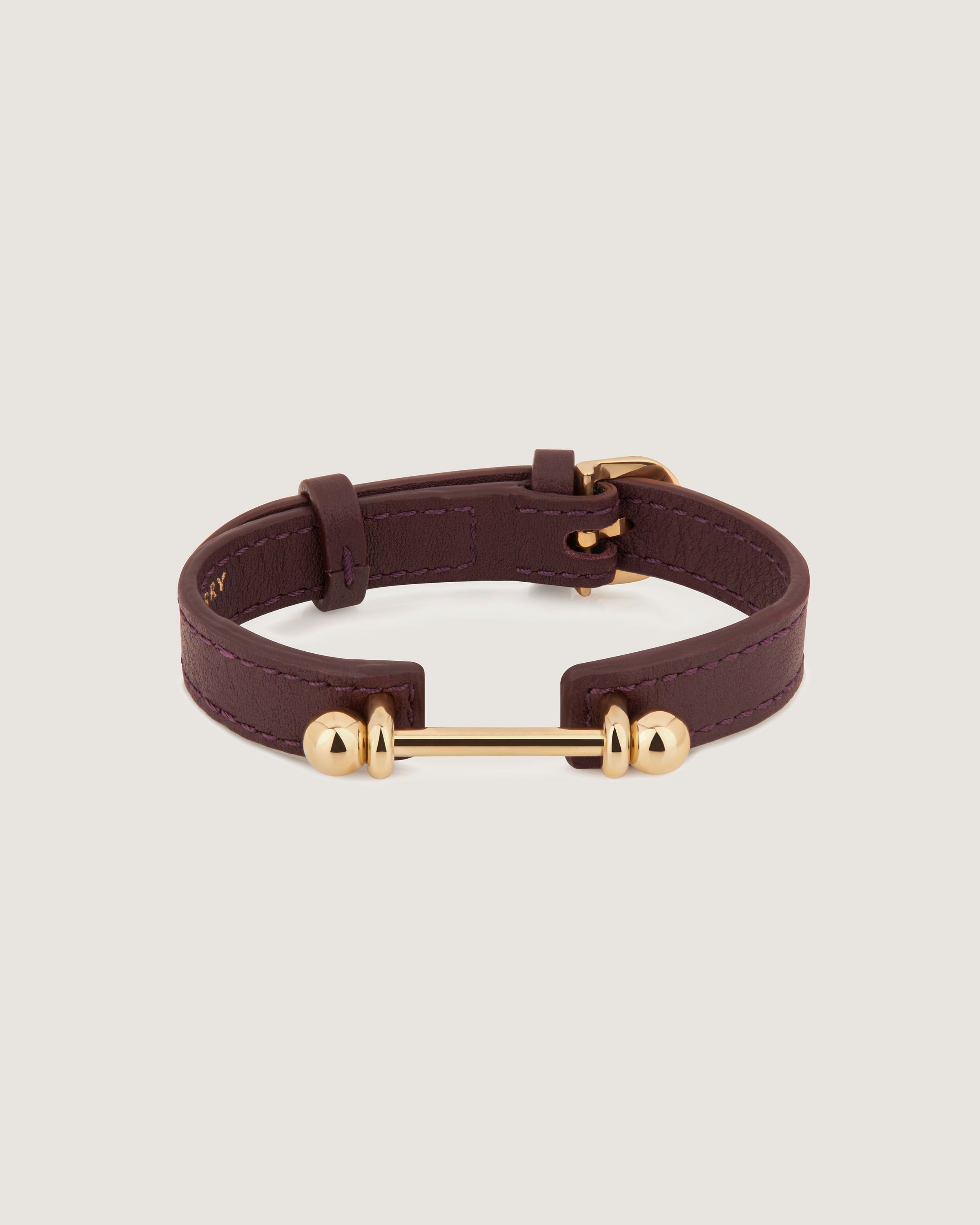 A brown leather bracelet with gold fittings