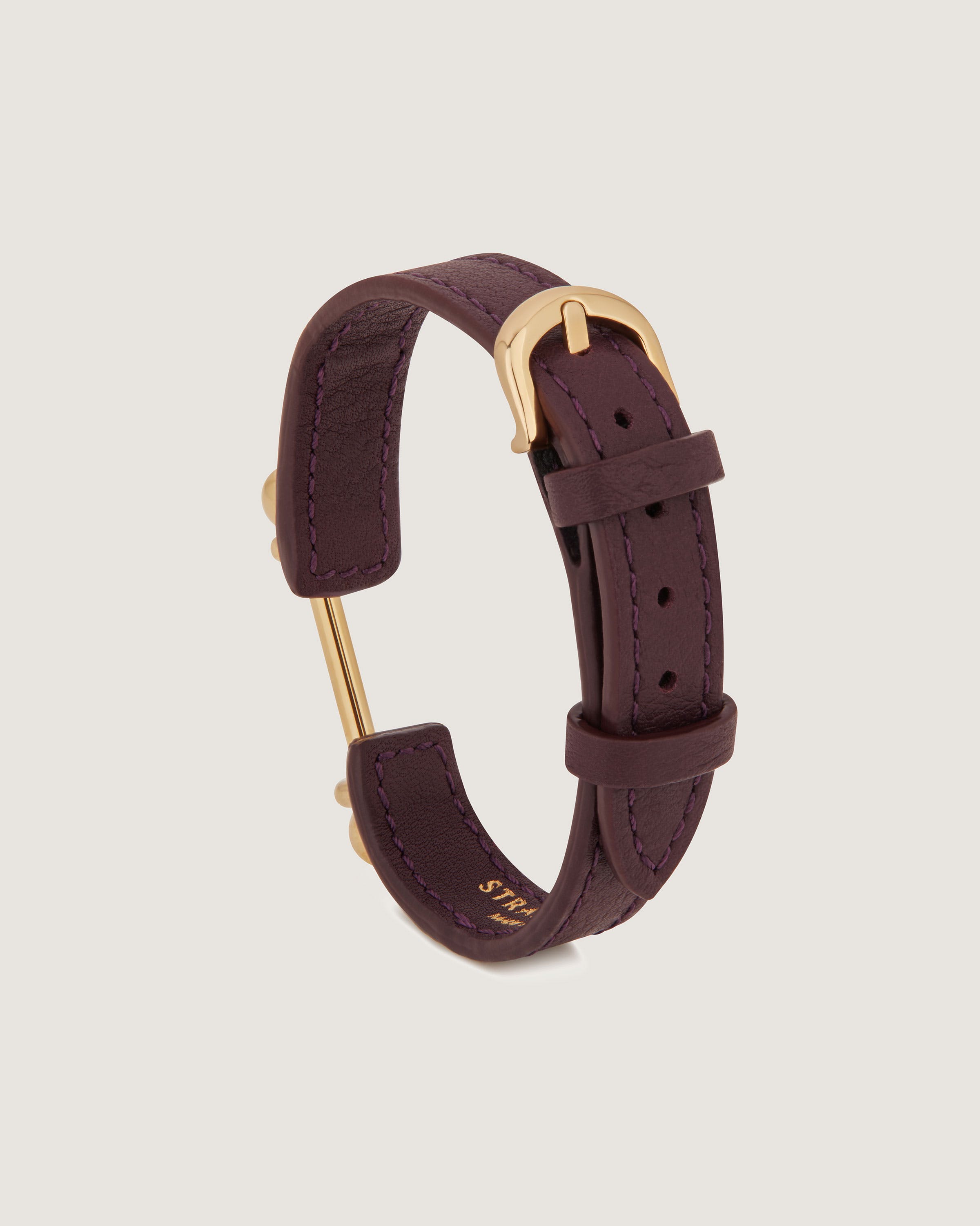 A purple leather bracelet with a gold clasp