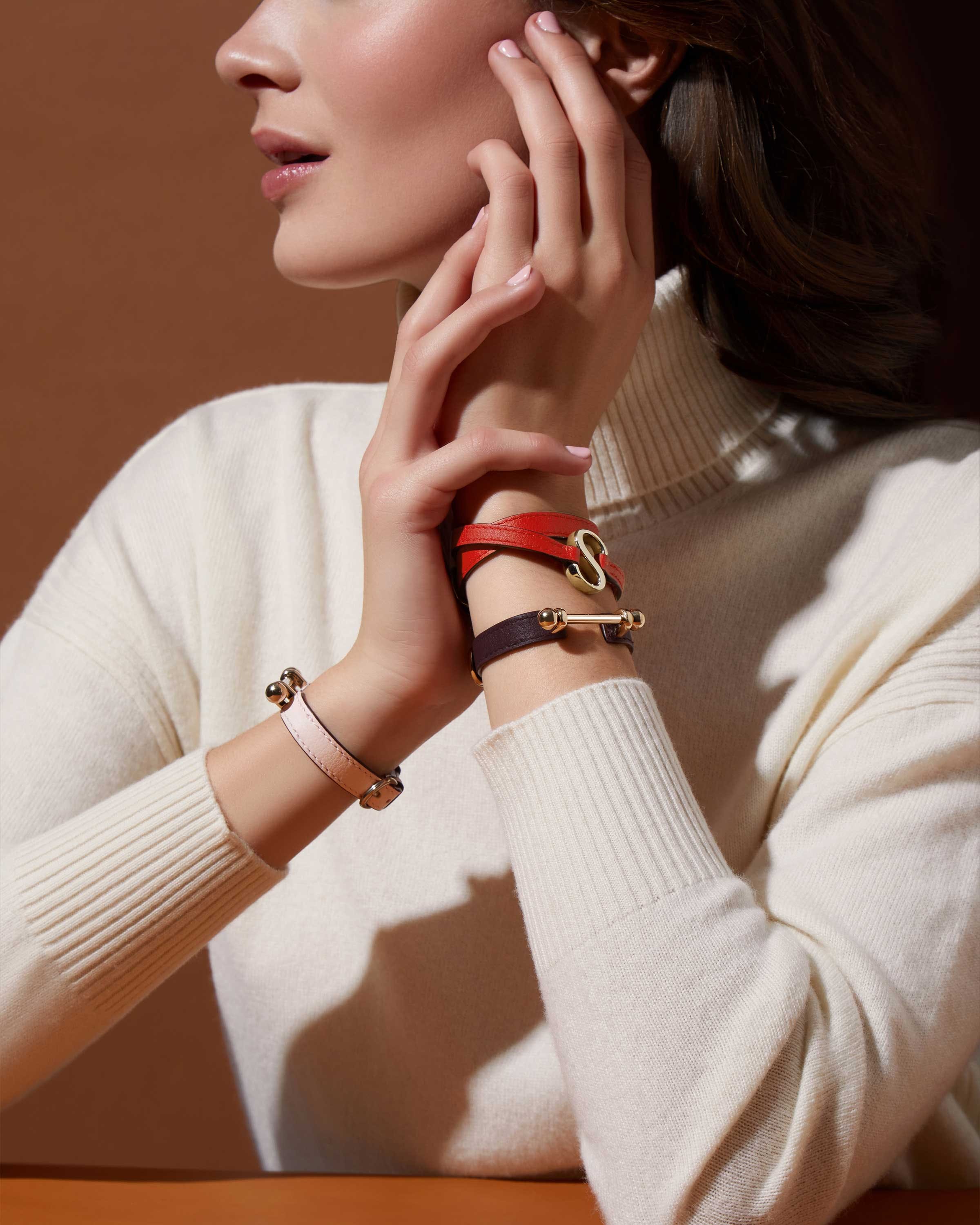 A woman wearing a white sweater and a red bracelet