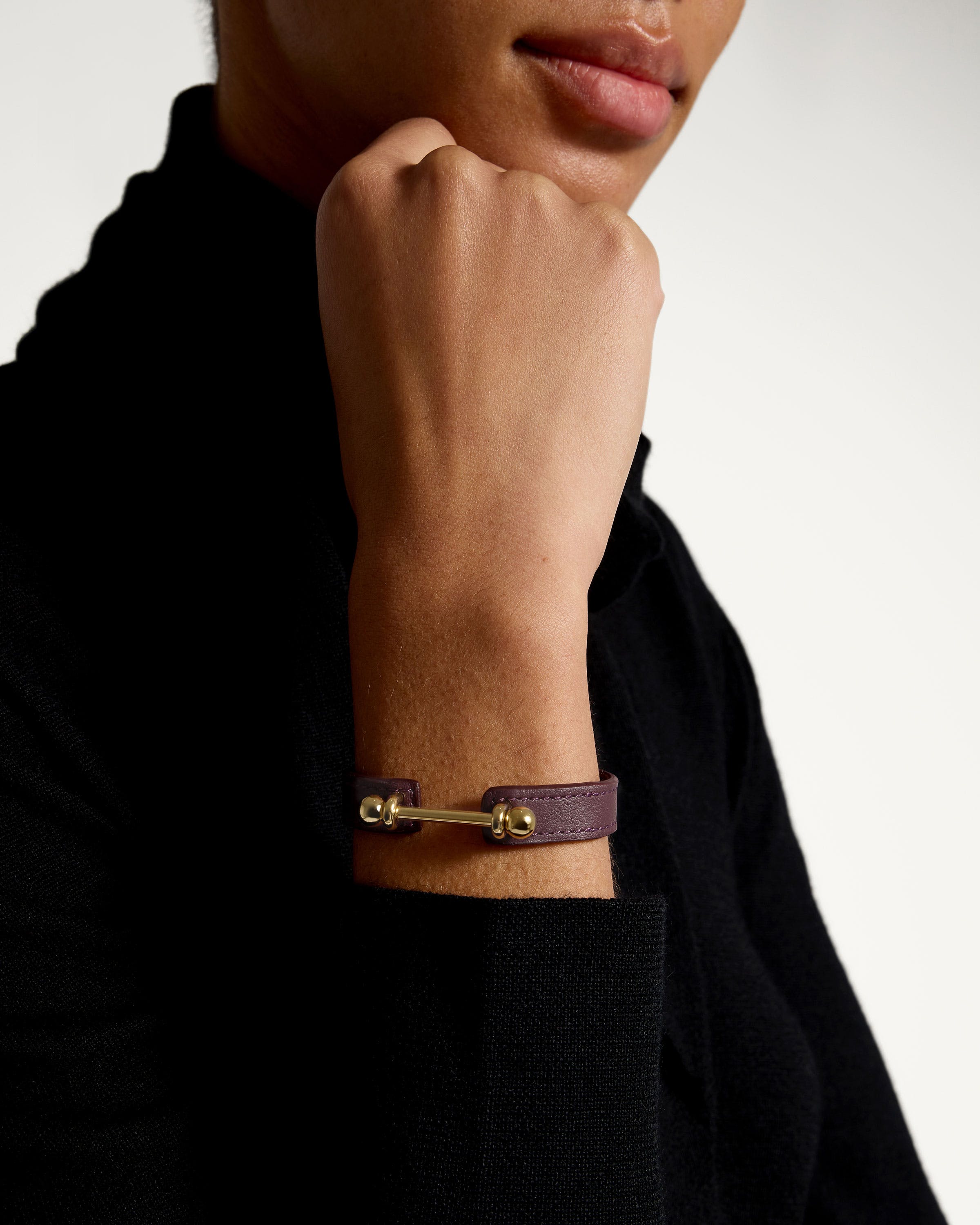 A man wearing a purple bracelet with a gold clasp