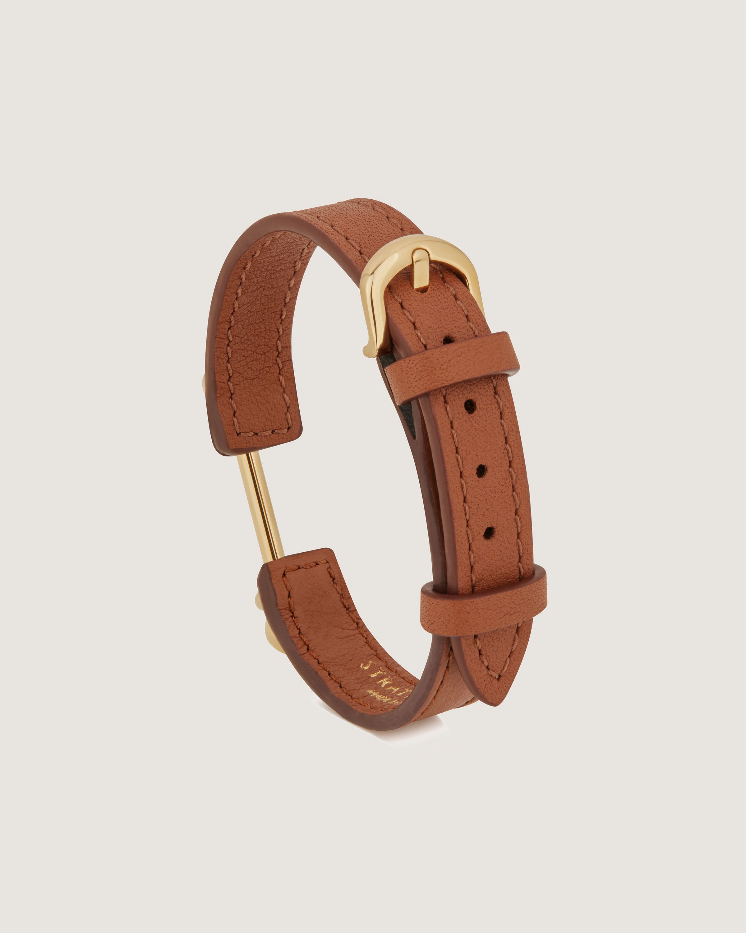 A brown leather bracelet with a gold clasp