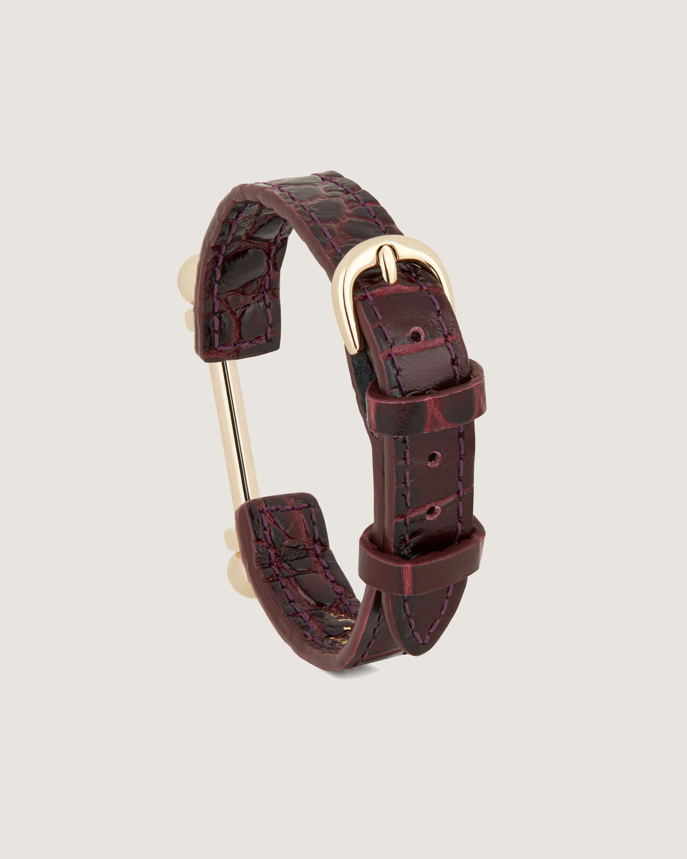 A brown leather bracelet with a gold clasp