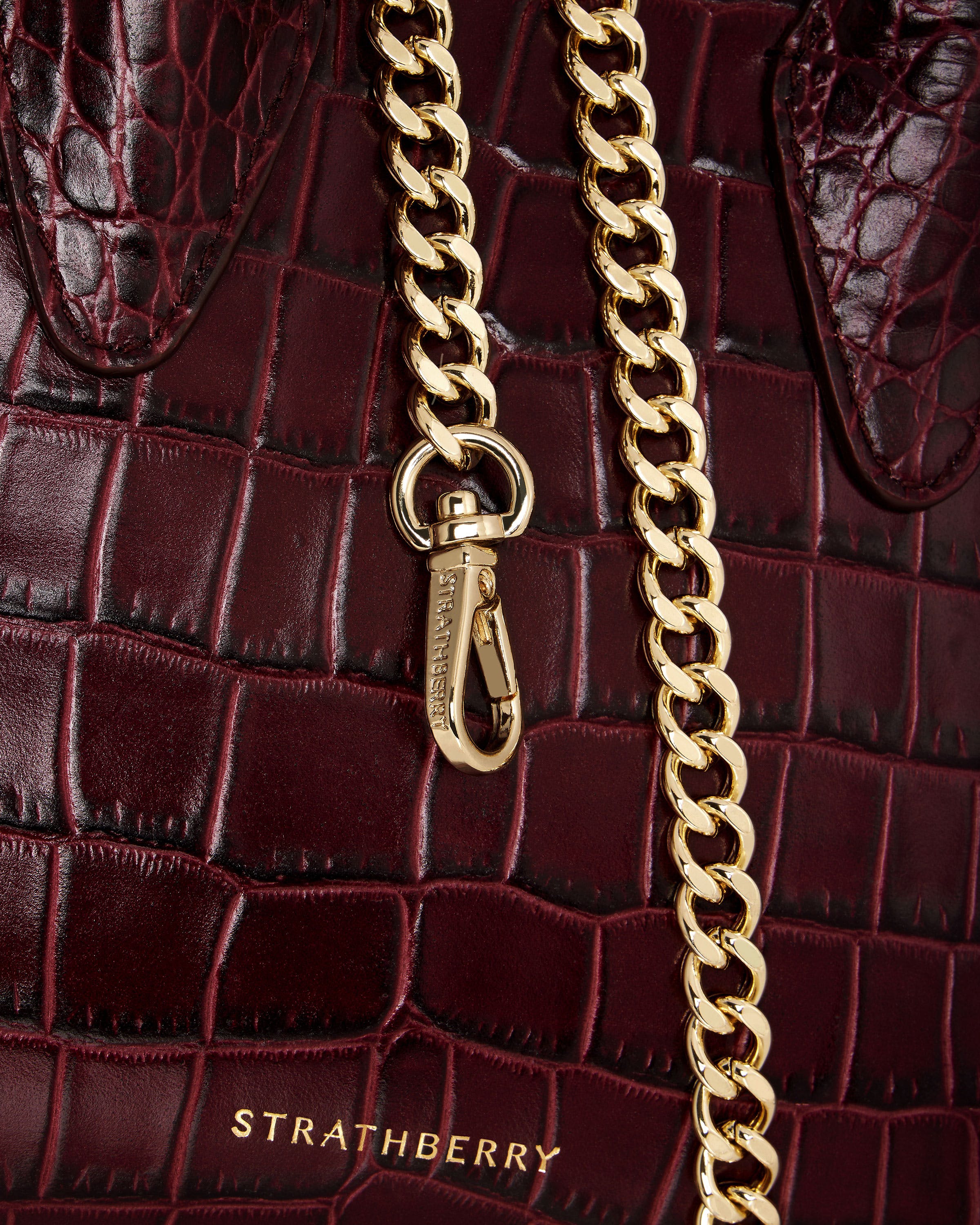 A close up of a handbag with a gold chain