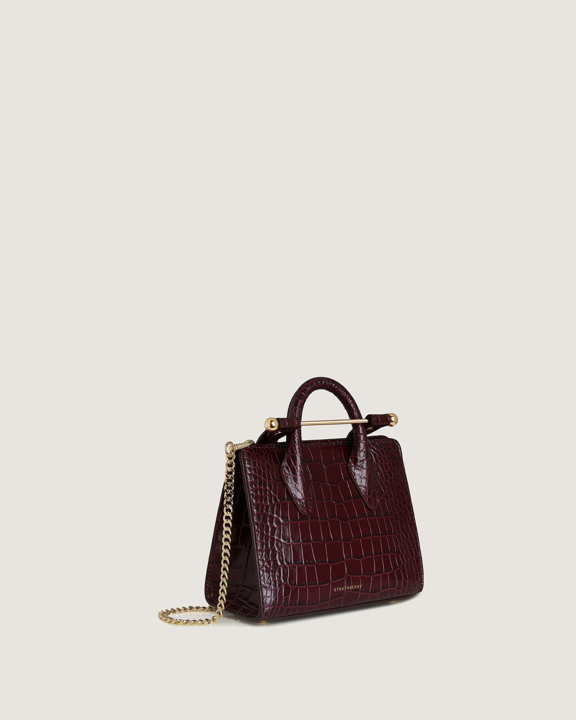 A small burgundy handbag with a gold chain