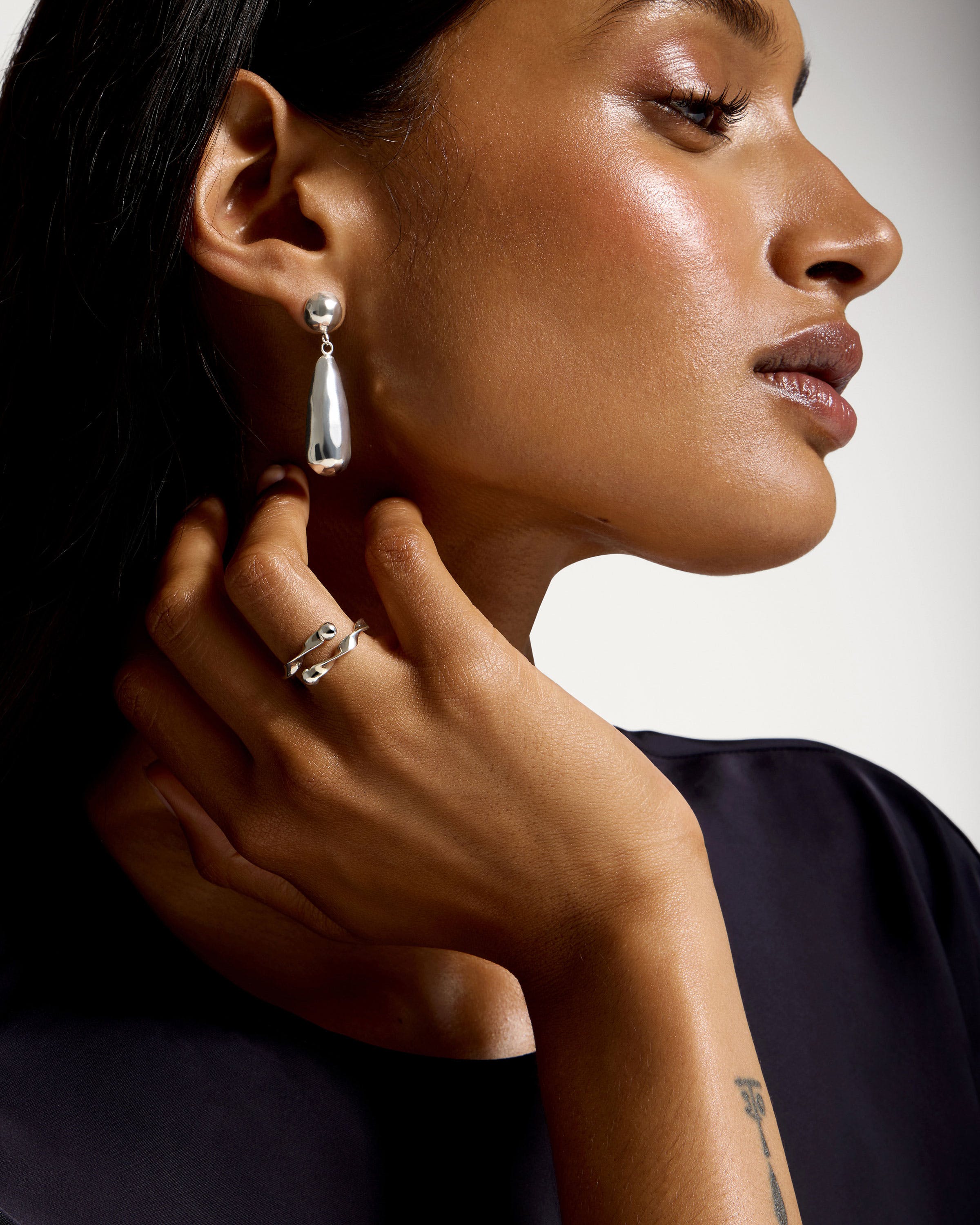 A woman wearing a pair of earrings and a ring