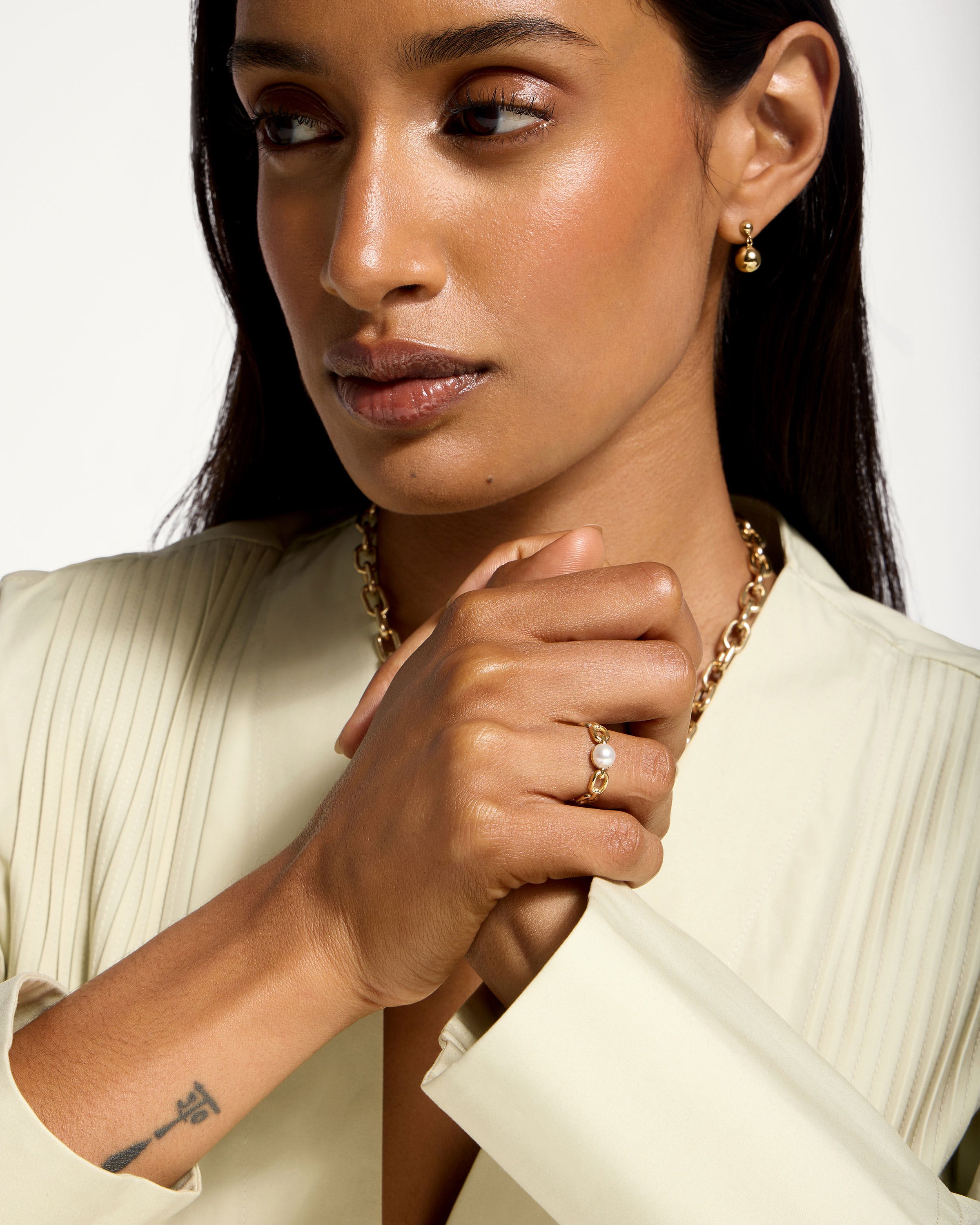 A woman wearing a white shirt and a gold necklace