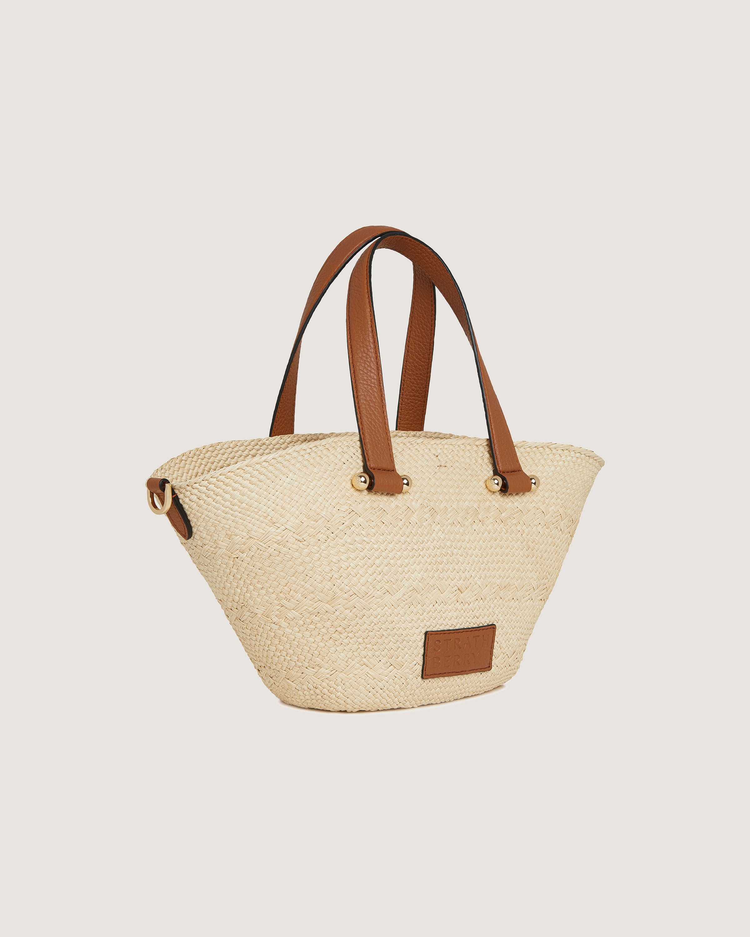 A straw bag with a brown leather handle