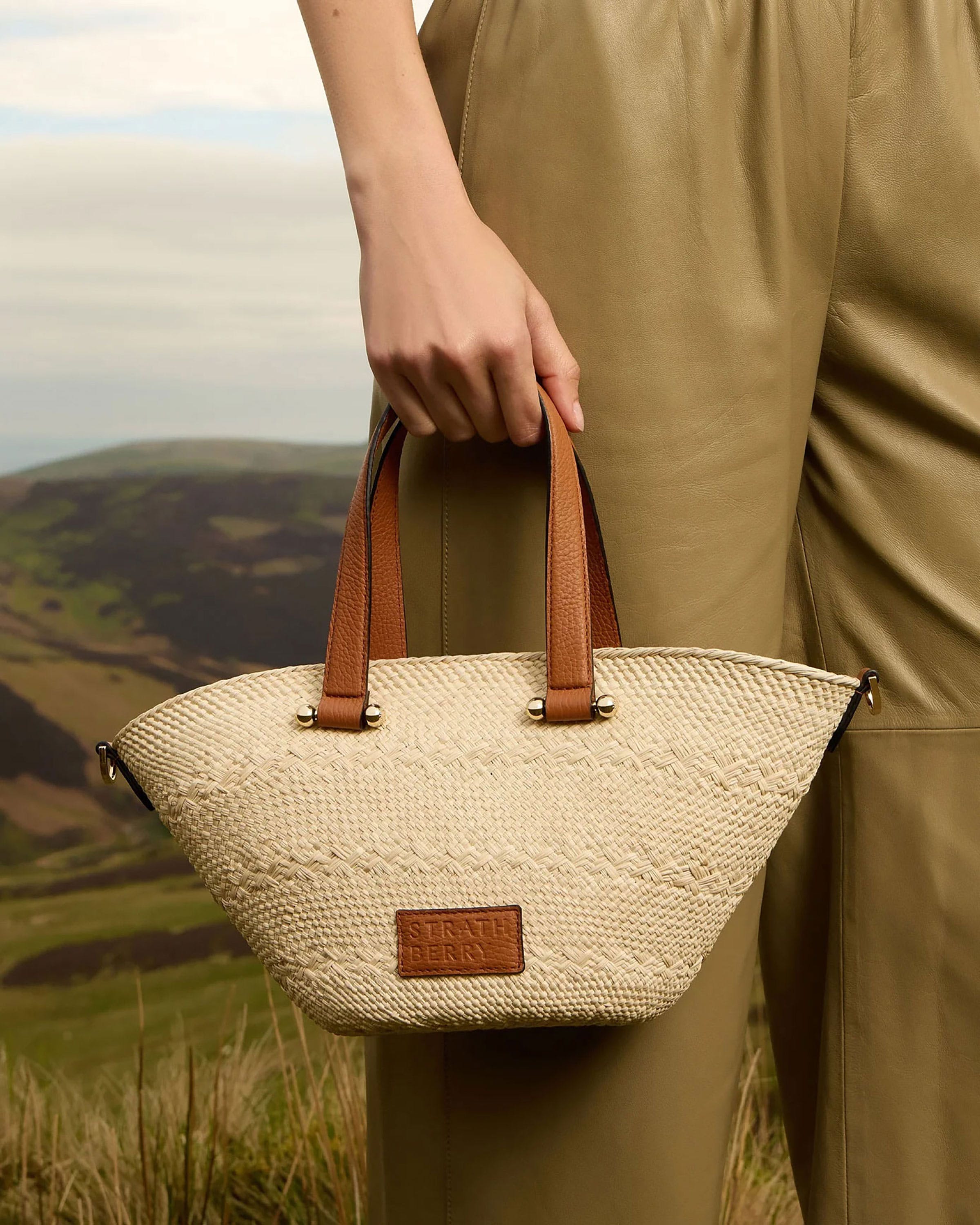 A person holding a white and brown bag