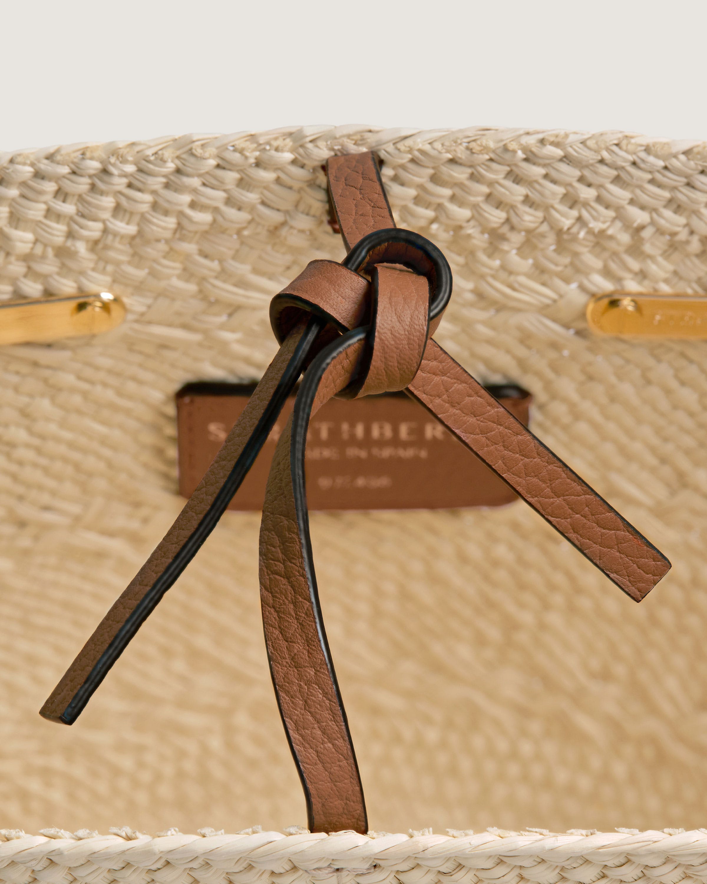 A close up of a straw bag with a ribbon