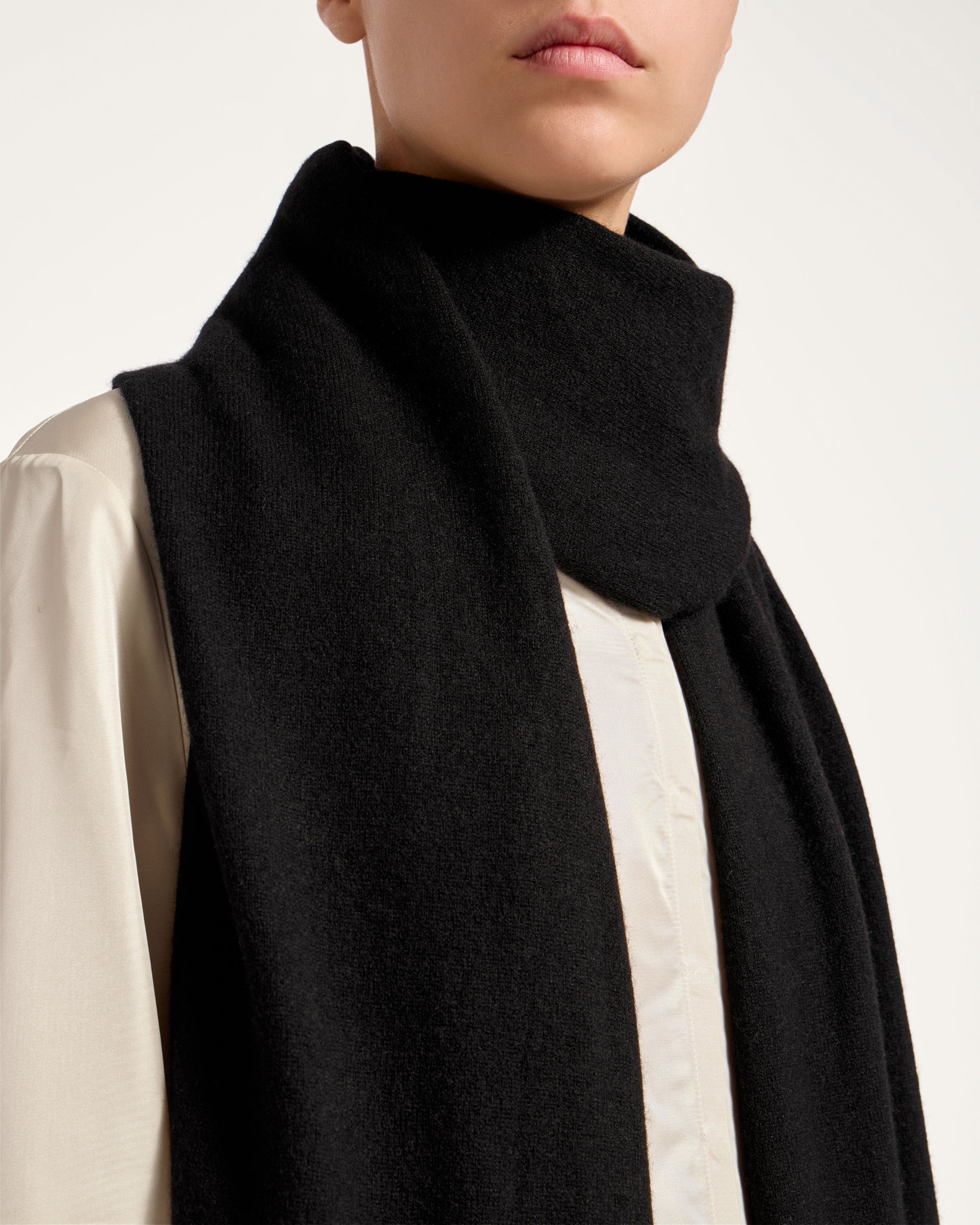 A woman wearing a black scarf and a white shirt