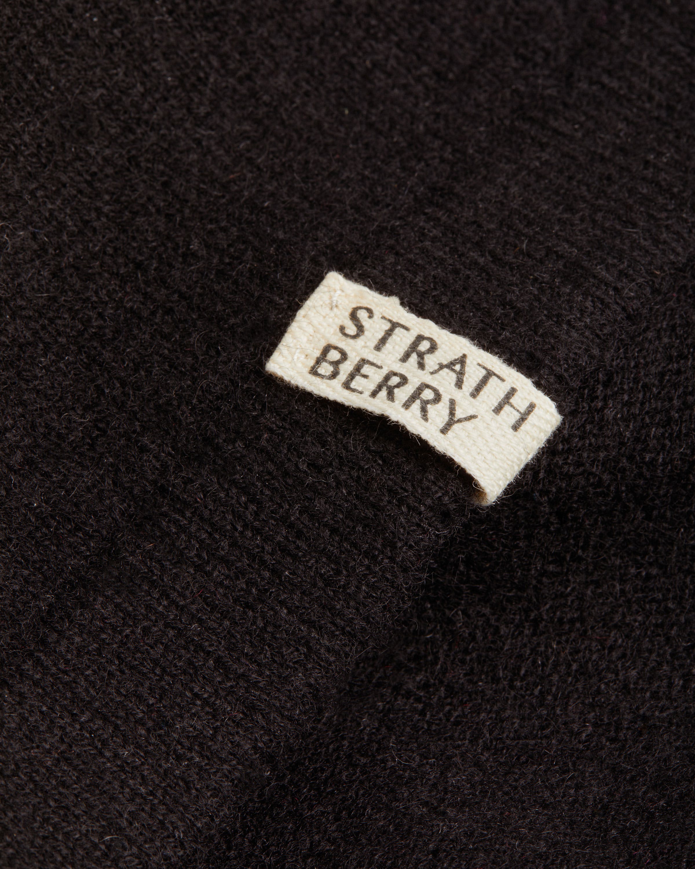 A black sweater with a white patch on it