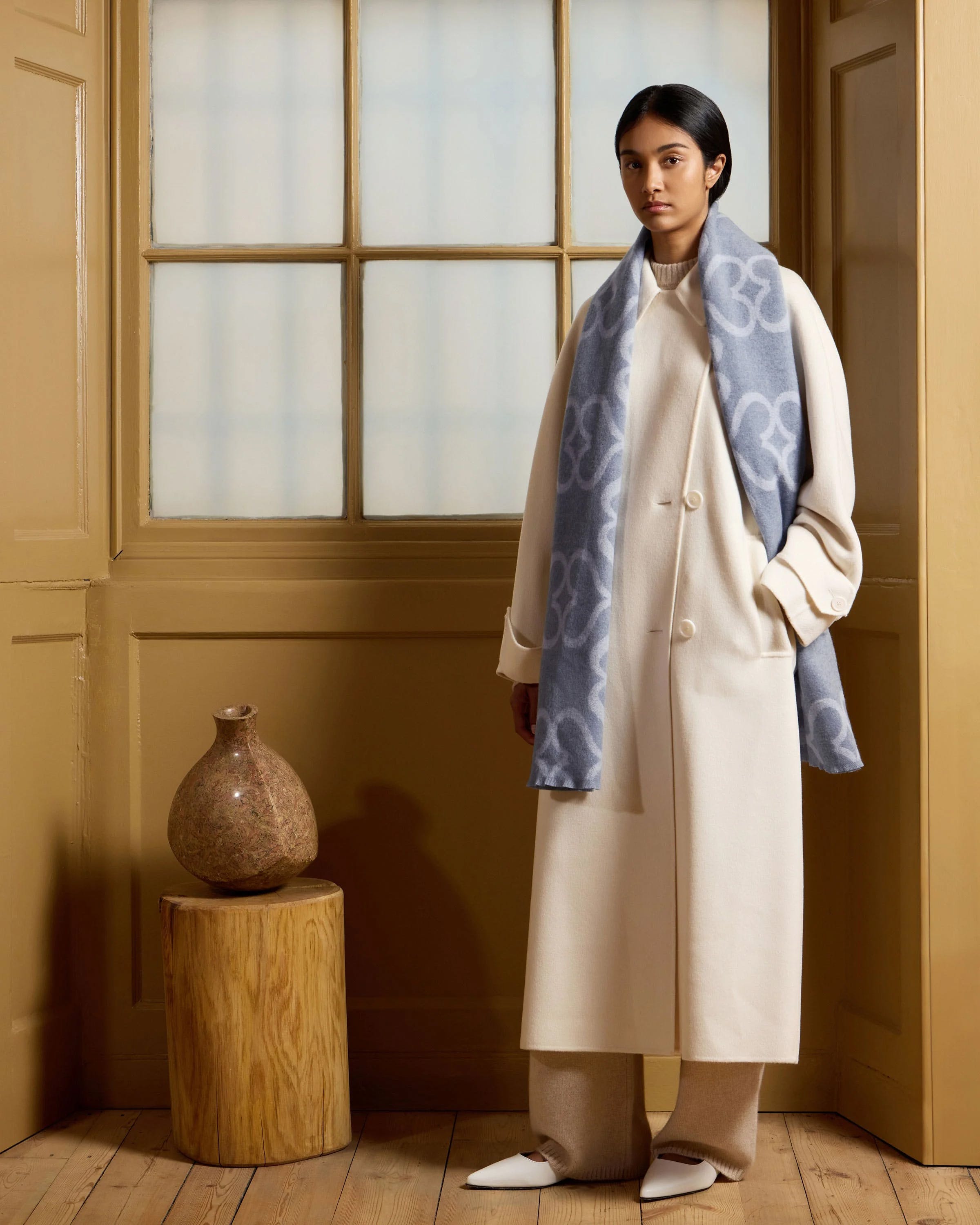 A woman standing in front of a window in a room