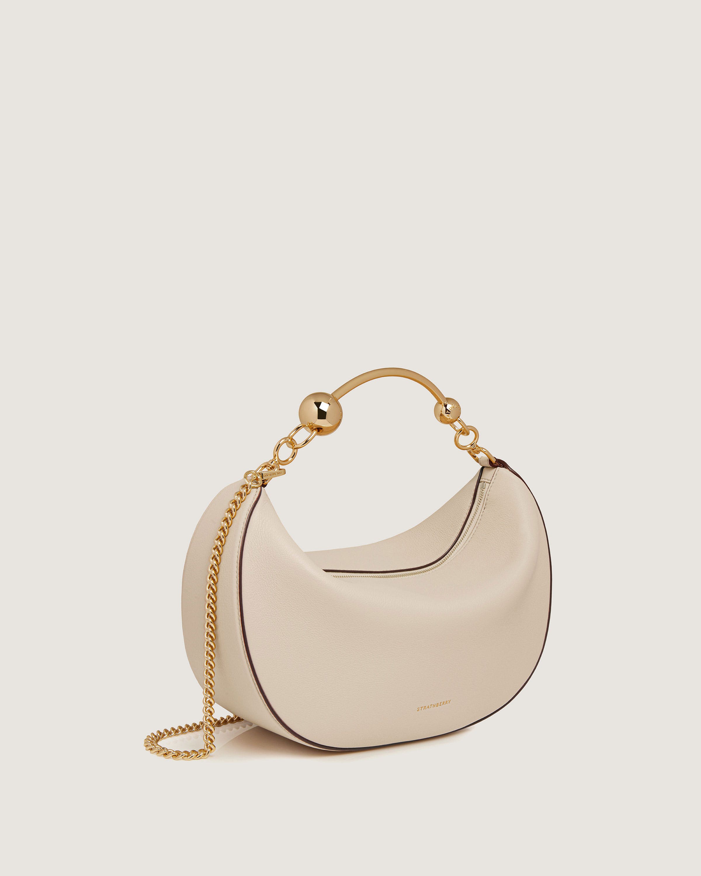 A white handbag with a gold chain