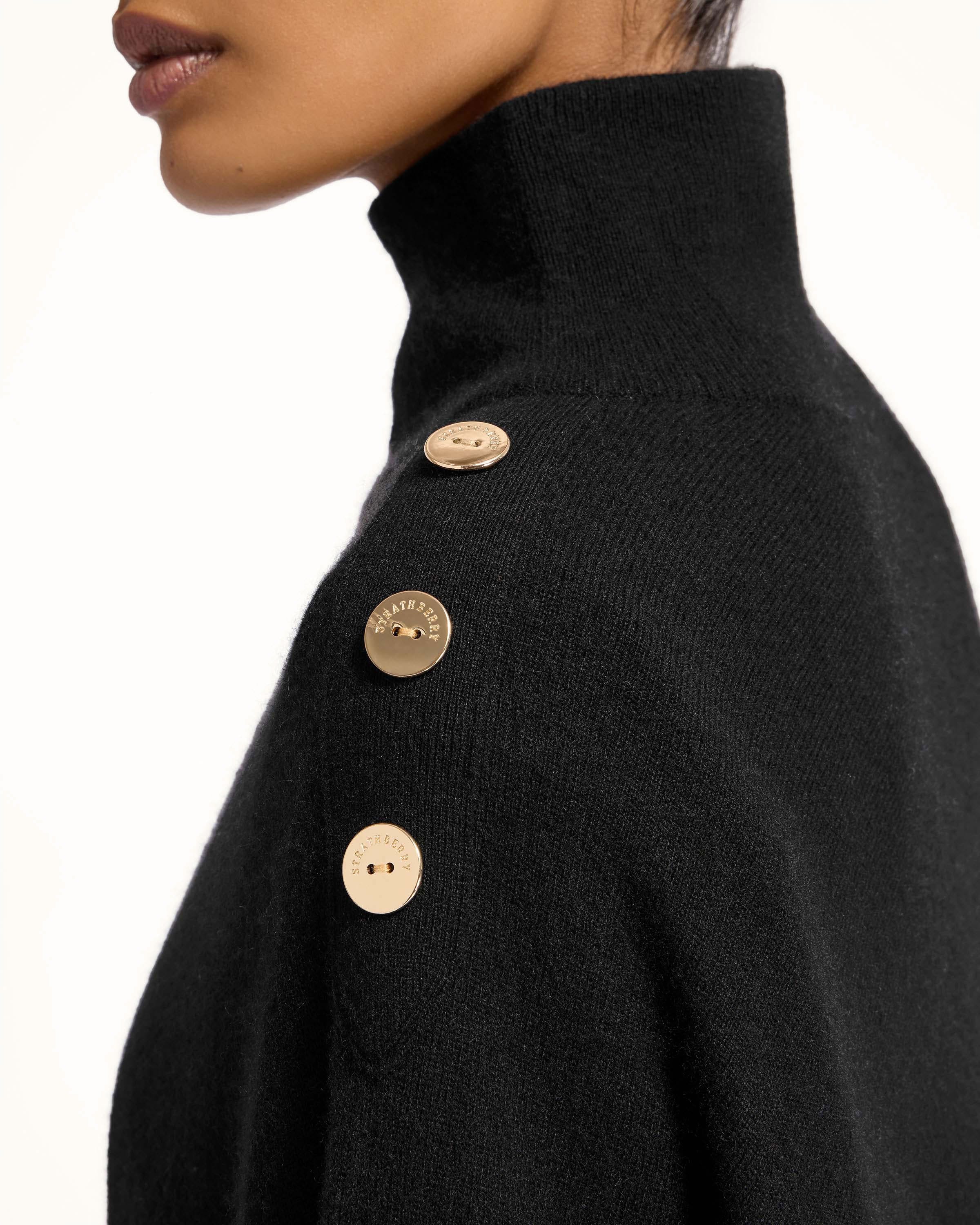 A woman wearing a black sweater with buttons