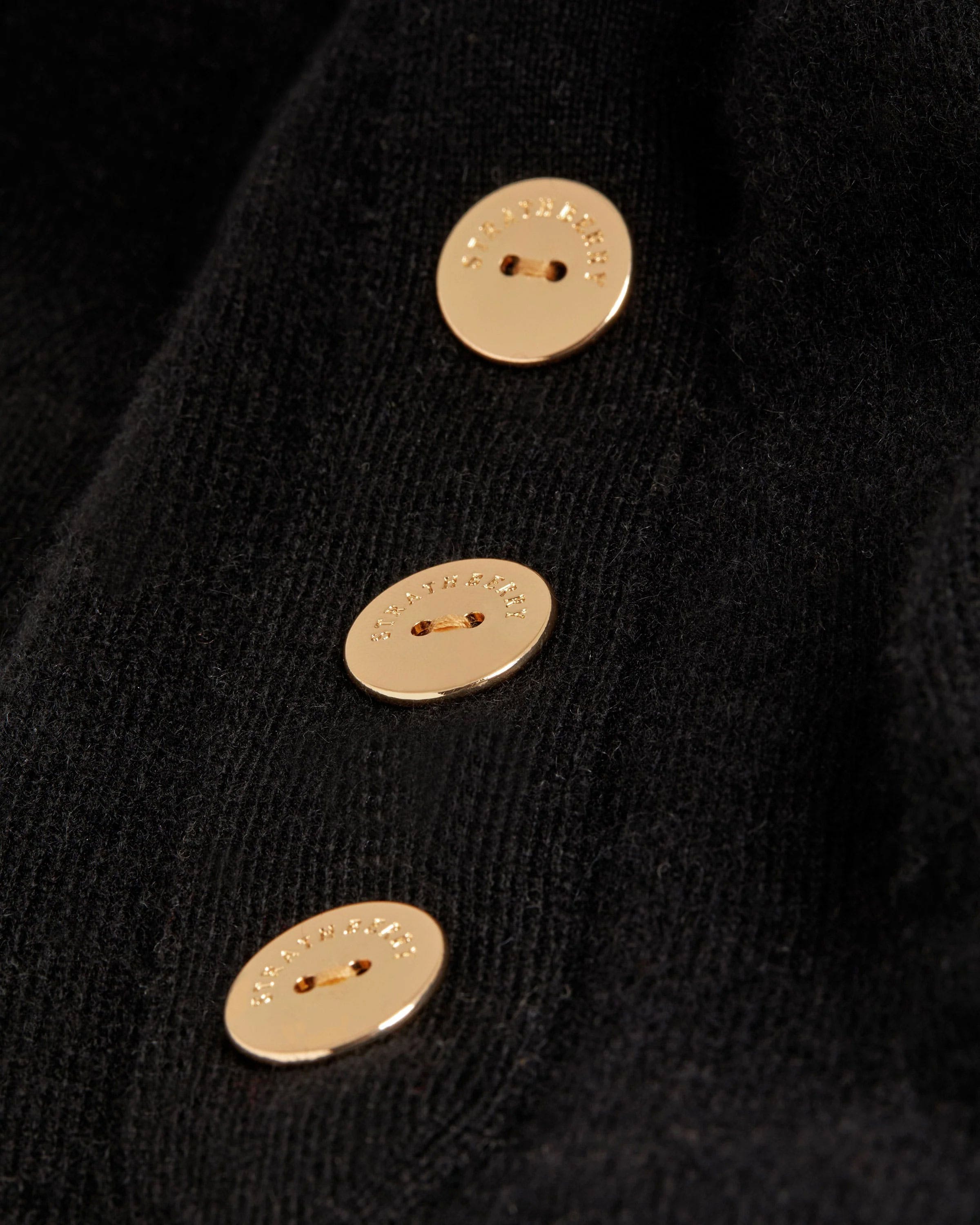 A close up of a button on a black sweater