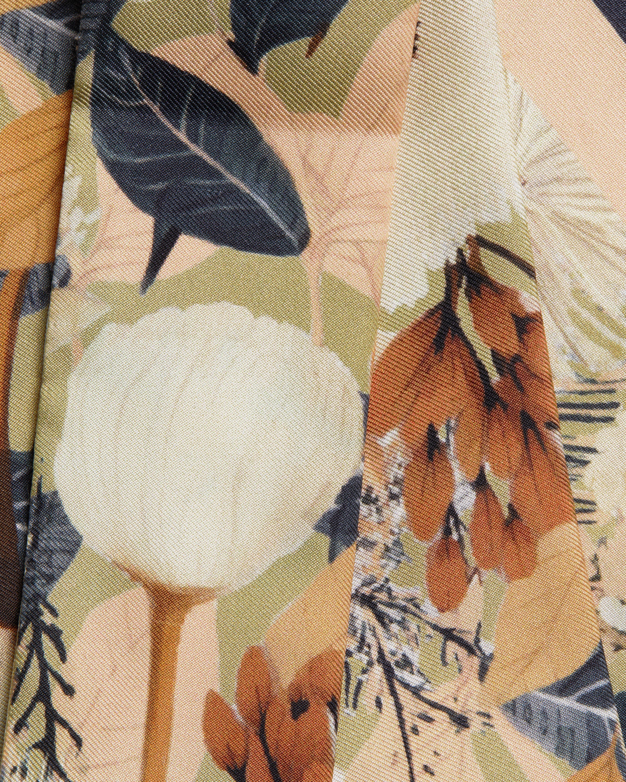 A close up of a tie with flowers and leaves on it