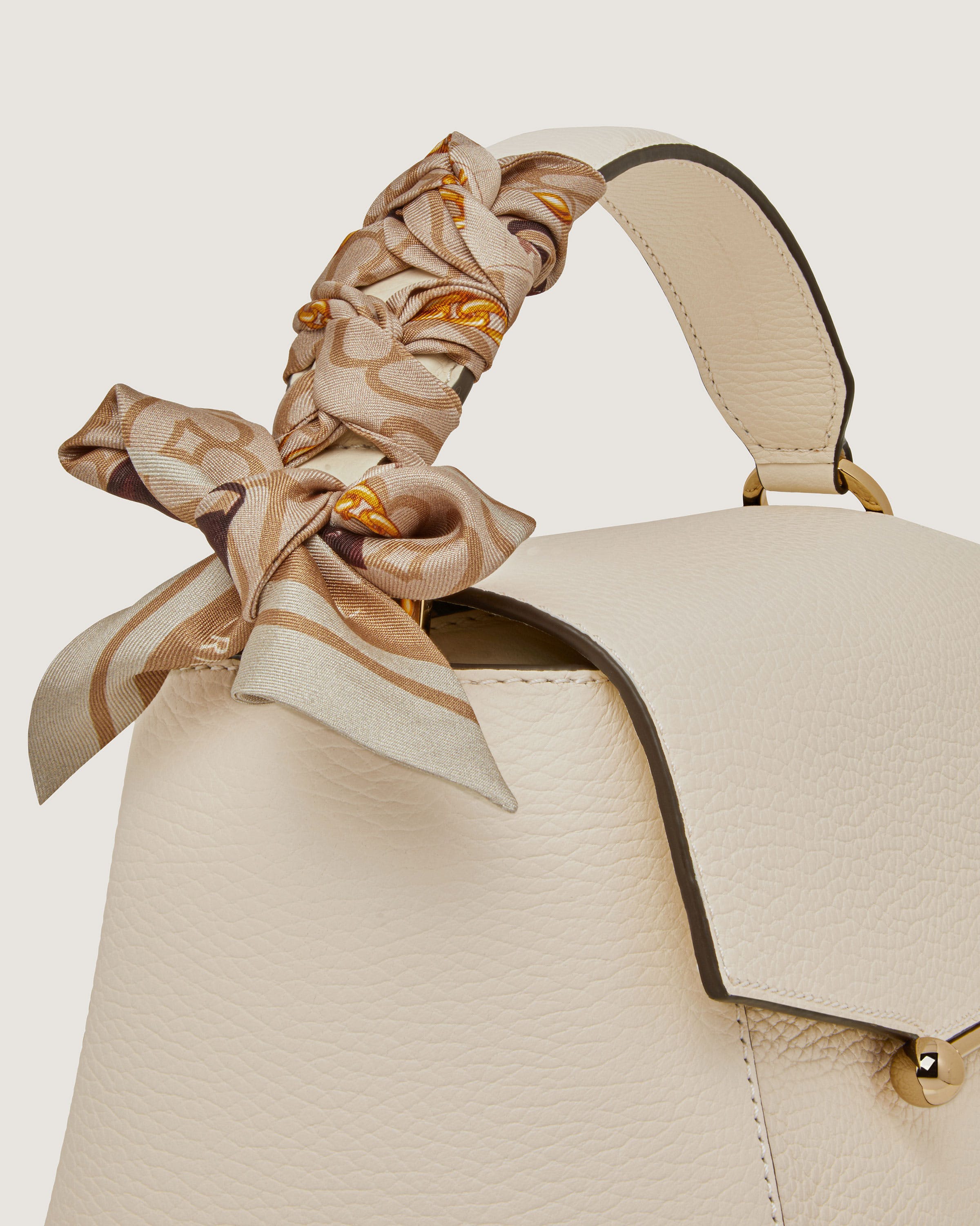 A handbag with a bow on the handle