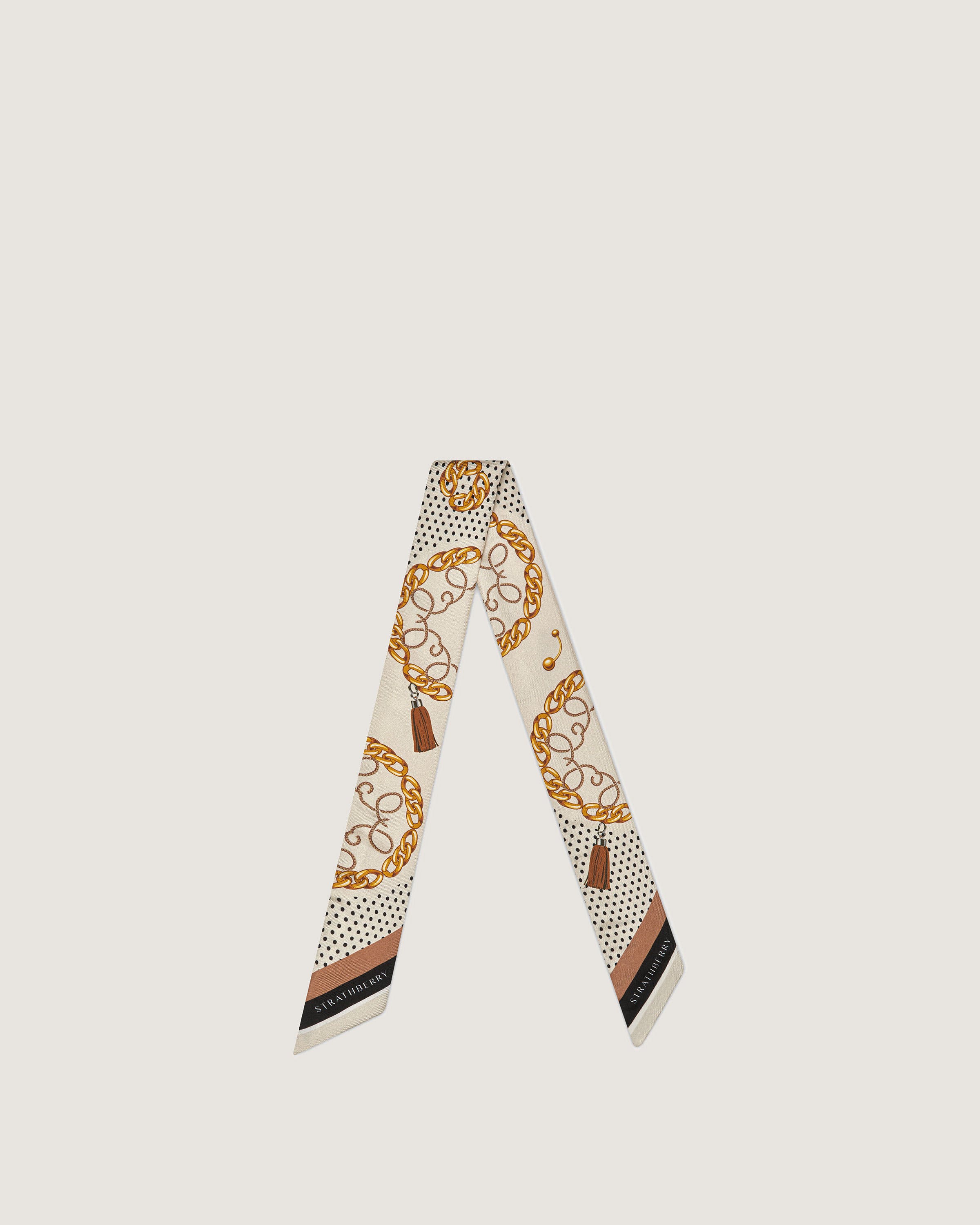 A white scarf with a gold and black design