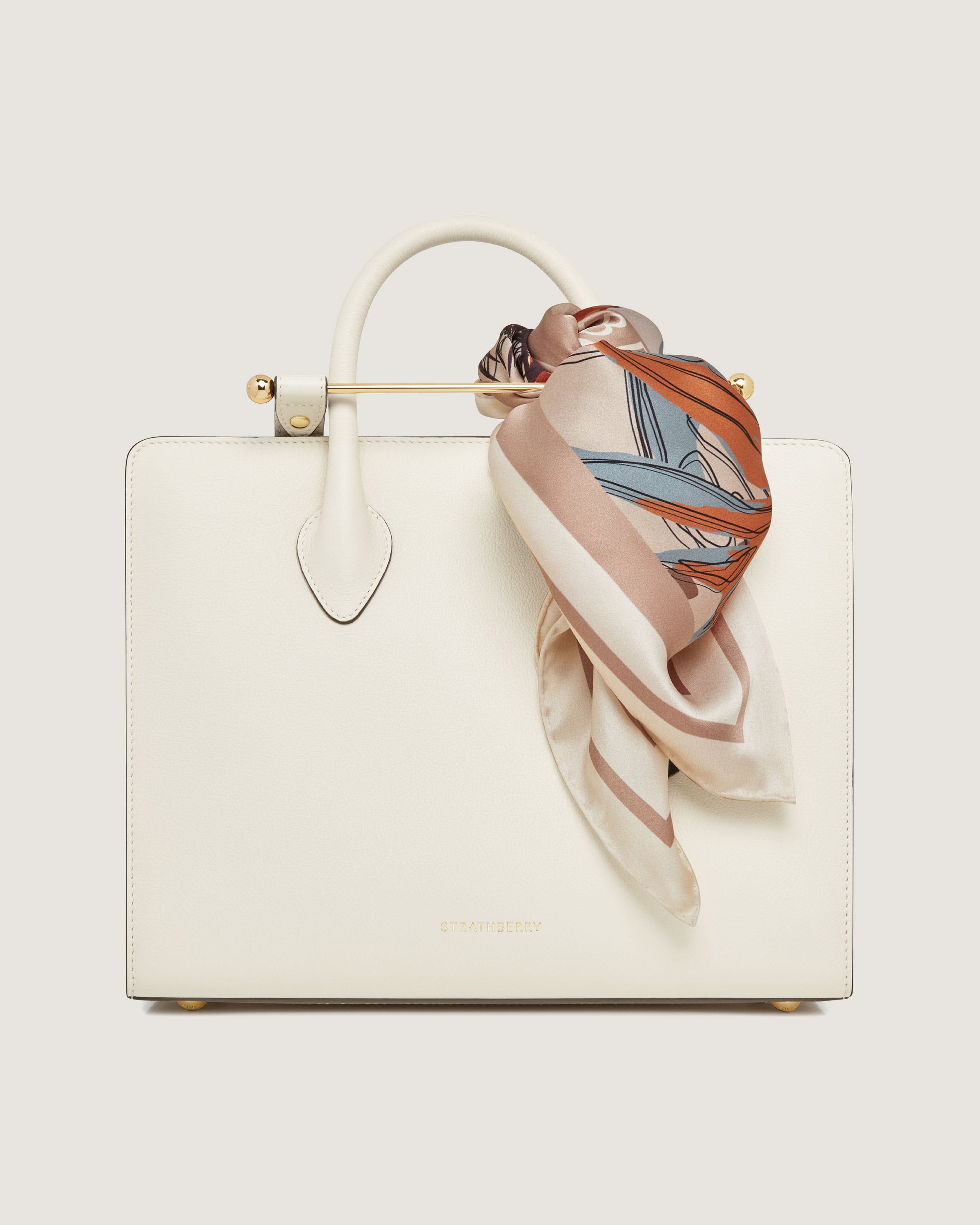 A white purse with a scarf on top of it