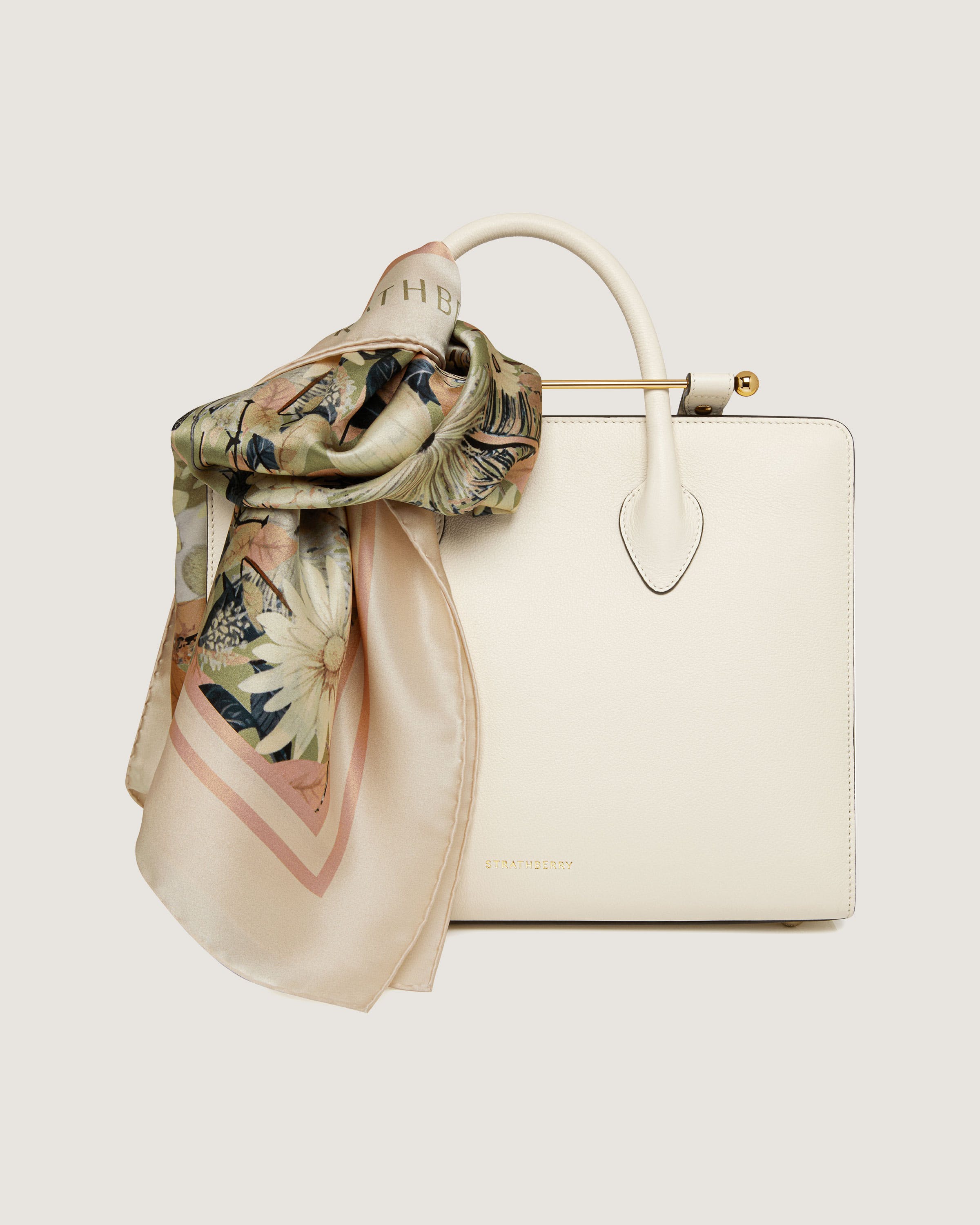 A white purse with a scarf on top of it