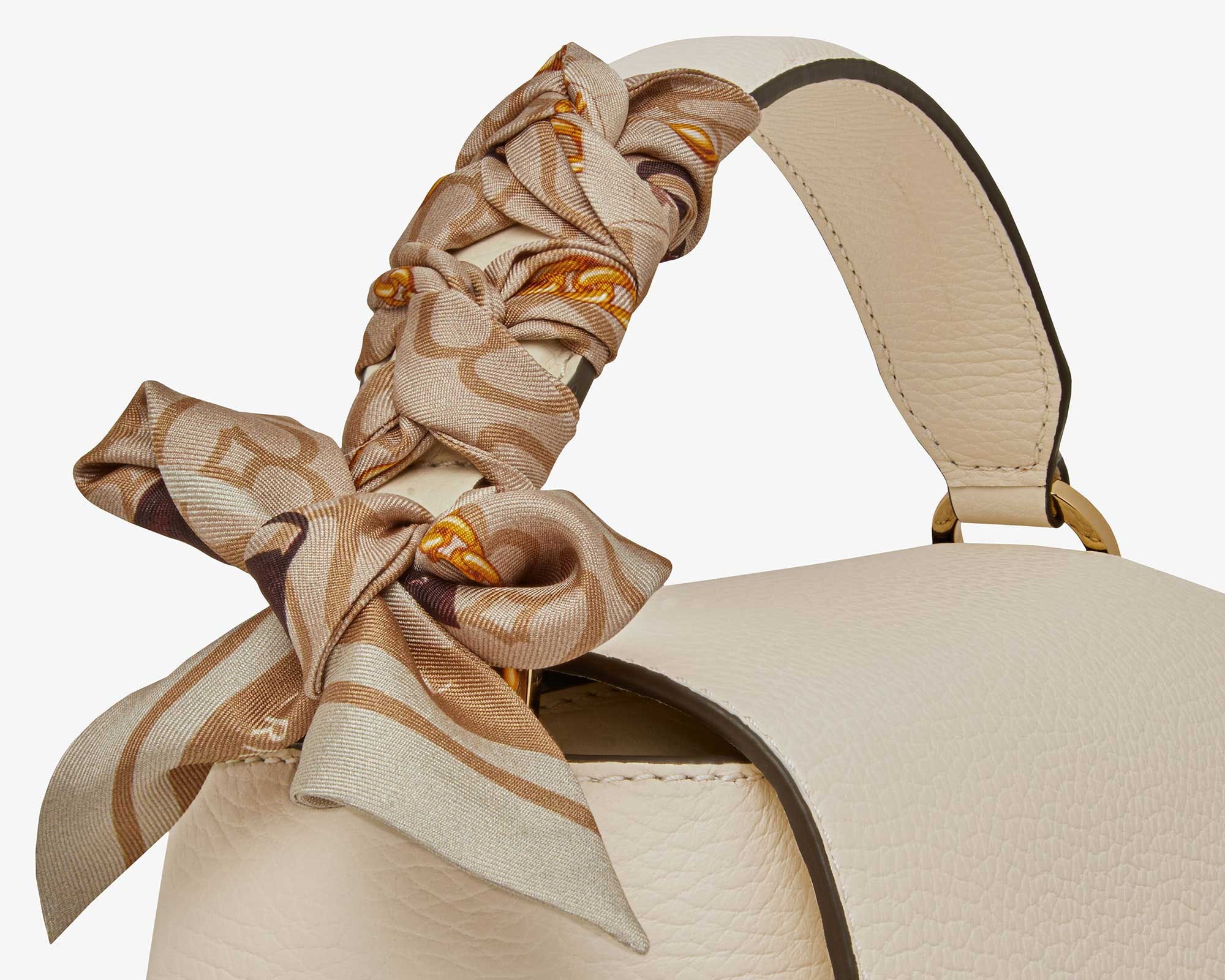 A white purse with a bow on top of it